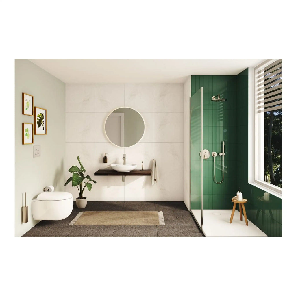 Contemporary bathroom featuring a walk-in shower with green tiles, modern floating vanity with round mirror, wall-mounted toilet, and decorative plants for a stylish, relaxing space.