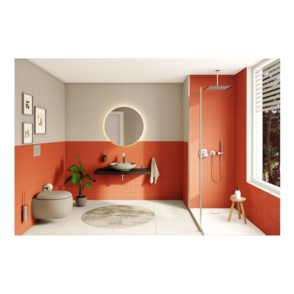 Sleek modern bathroom with bold orange tiled walls, minimalist sink vanity, round mirror with backlighting, spacious shower area, and contemporary decor perfect for stylish bathroom design.