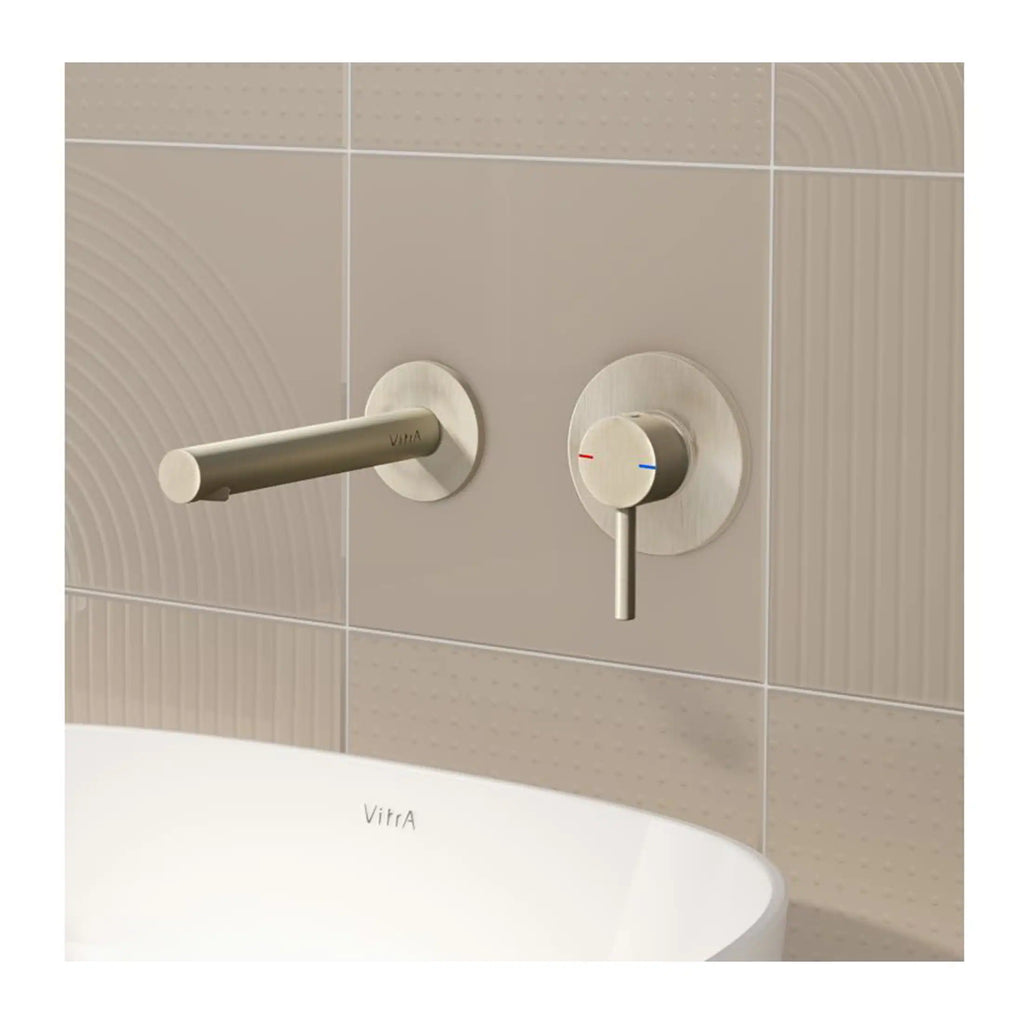 Brushed stainless steel bathroom faucet and temperature control valve on beige tiled wall, modern bathroom fixtures.