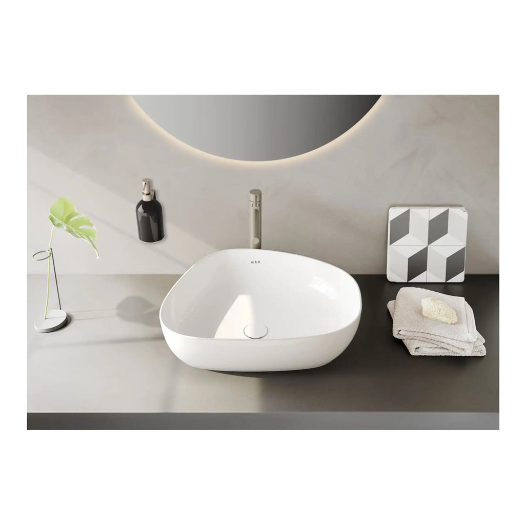 Sleek white bathroom vanity sink with modern design, positioned on a minimalist grey surface with decorative accents, ideal for contemporary bathroom interiors with premium fittings.