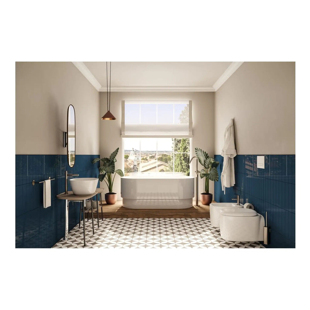 Modern blue and white bathroom featuring a freestanding bathtub, bidet, wash basin, wall mirror, and stylish decor with lush green plants and natural light.