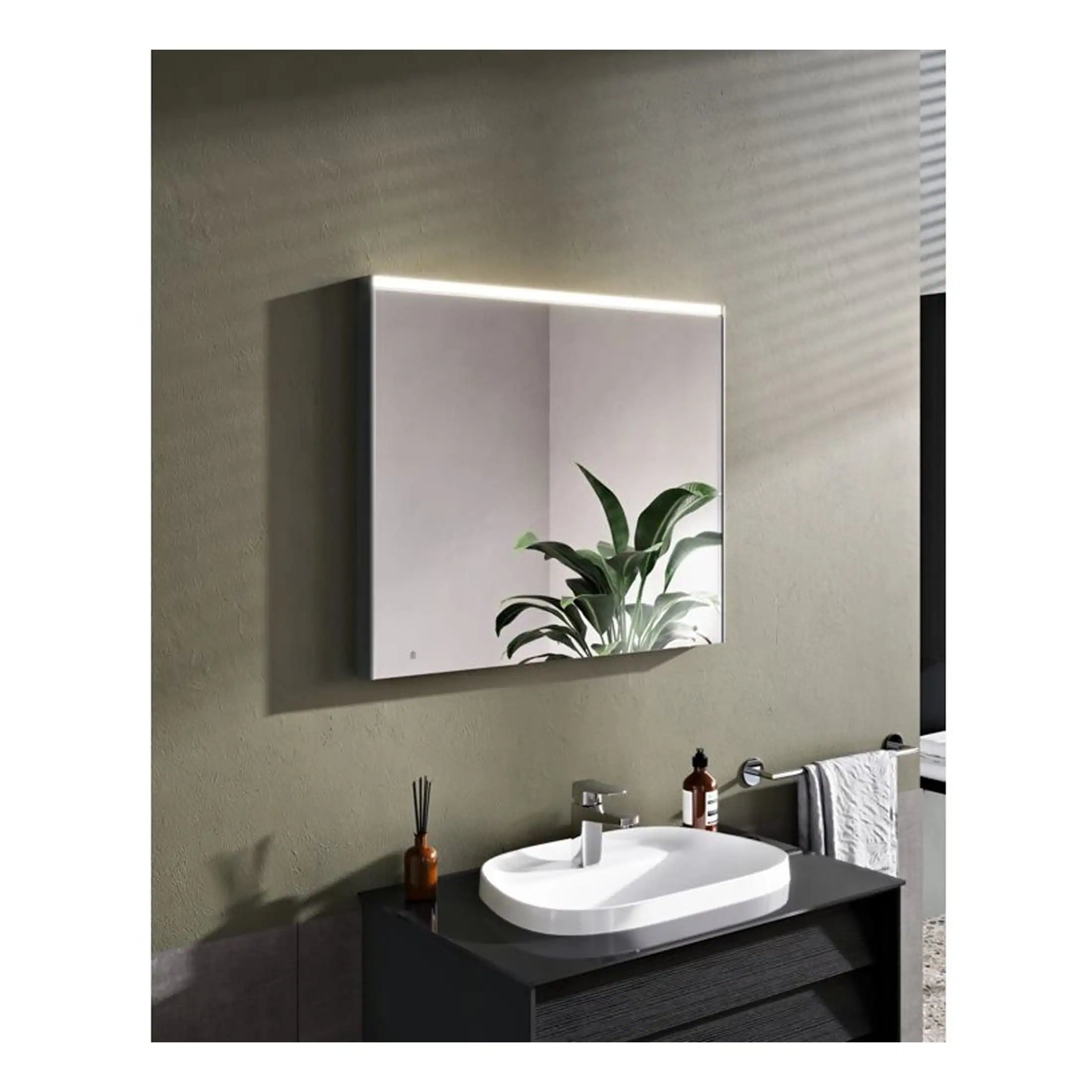 Sleek mirrored bathroom cabinet with integrated LED lightingabove modern white sink and black vanity unit, featuring a potted plant and bathroom accessories, ideal for contemporary Bubly Bathrooms decor.