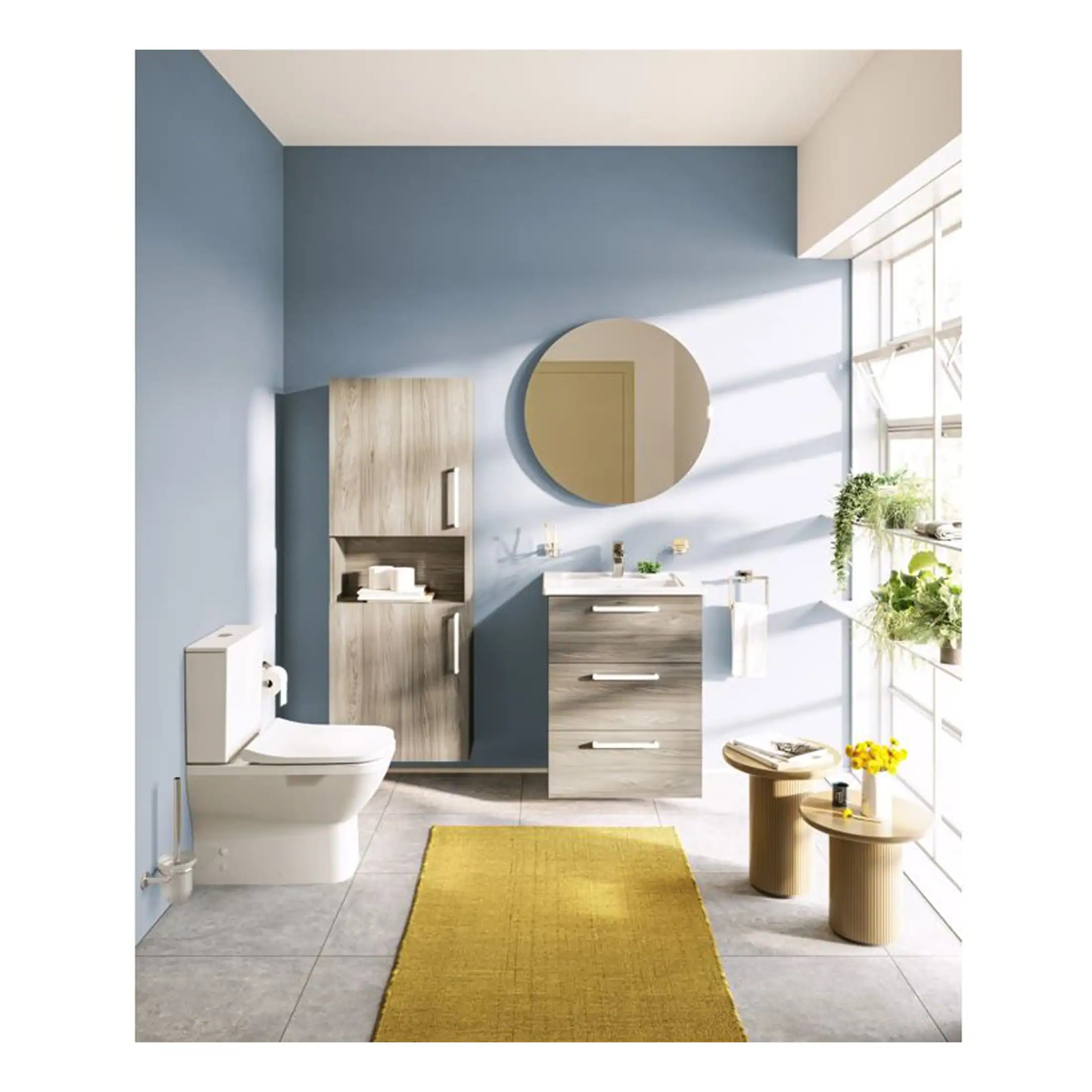 Modern bathroom with blue accent wall, wooden vanity units, wall-mounted cabinet, round mirror, white toilet, and contemporary decor with natural sunlight and indoor plants.