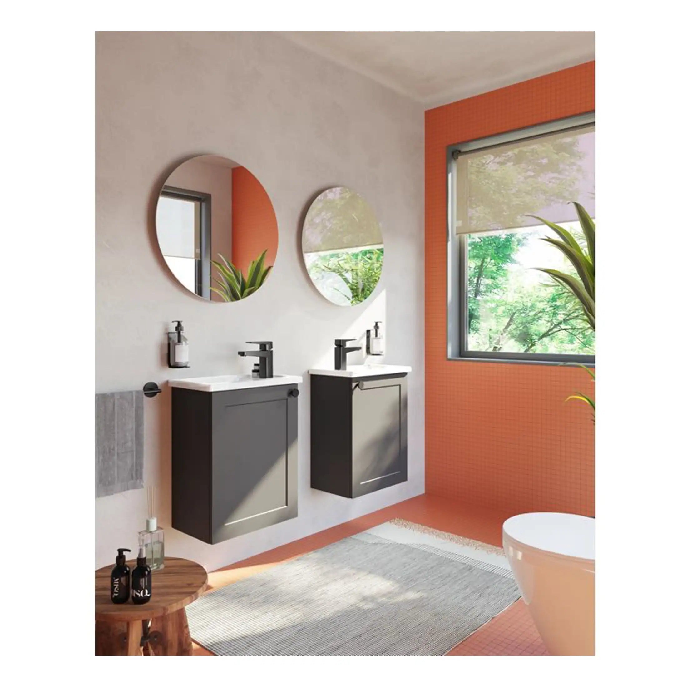 Sleek black bathroom vanity units with white countertops, modern black faucets, and round mirrors in a contemporary bathroom setting with natural light, indoor plants, and orange-tiled wall accents.