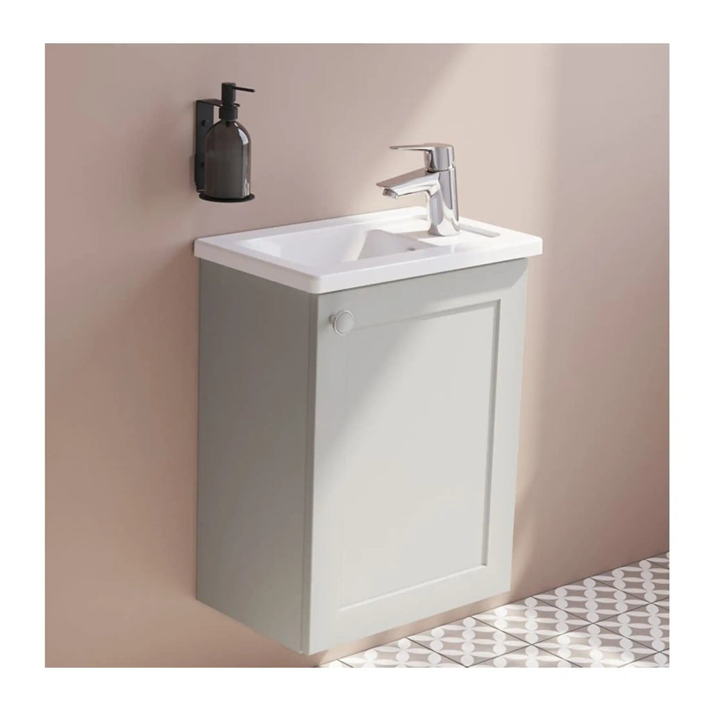 Smooth white bathroom vanity with integrated sink and chrome faucet, mounted on a soft grey wall with a wall-mounted black soap dispenser, perfect for modern bathroom designs.