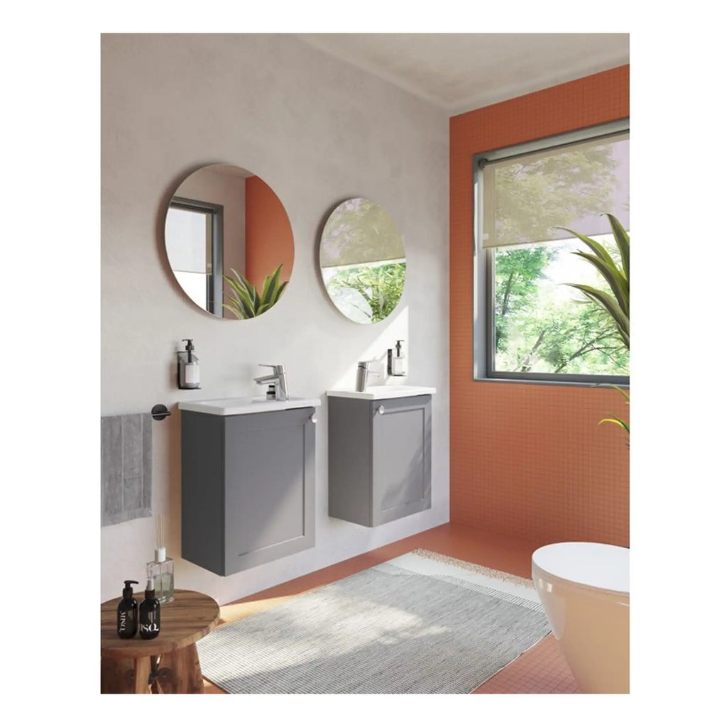 Contemporary double vanity bathroom with grey floating cabinets, round wall mirrors, large window with view of green trees, modern fixtures, soft natural lighting, and stylish decor.