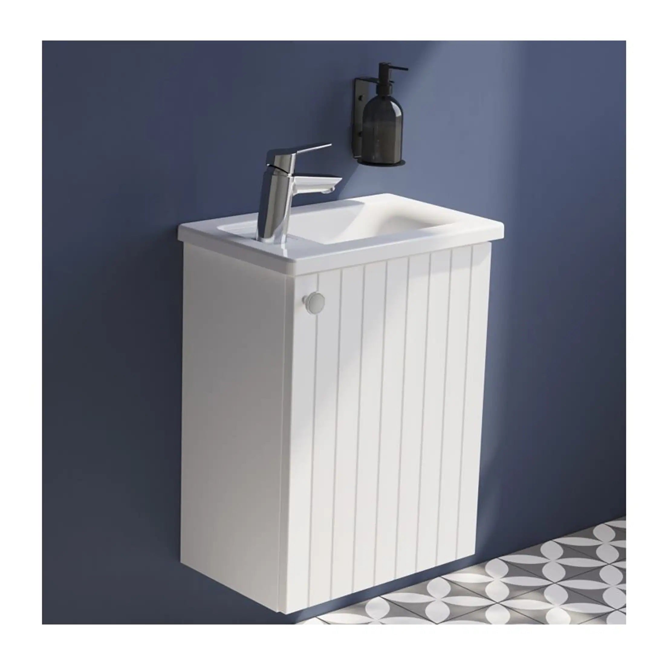 Mini white bathroom vanity with sink and chrome faucet, wall-mounted cabinet with vertical panel design, against blue wall with black soap dispenser, modern bathroom storage solution.