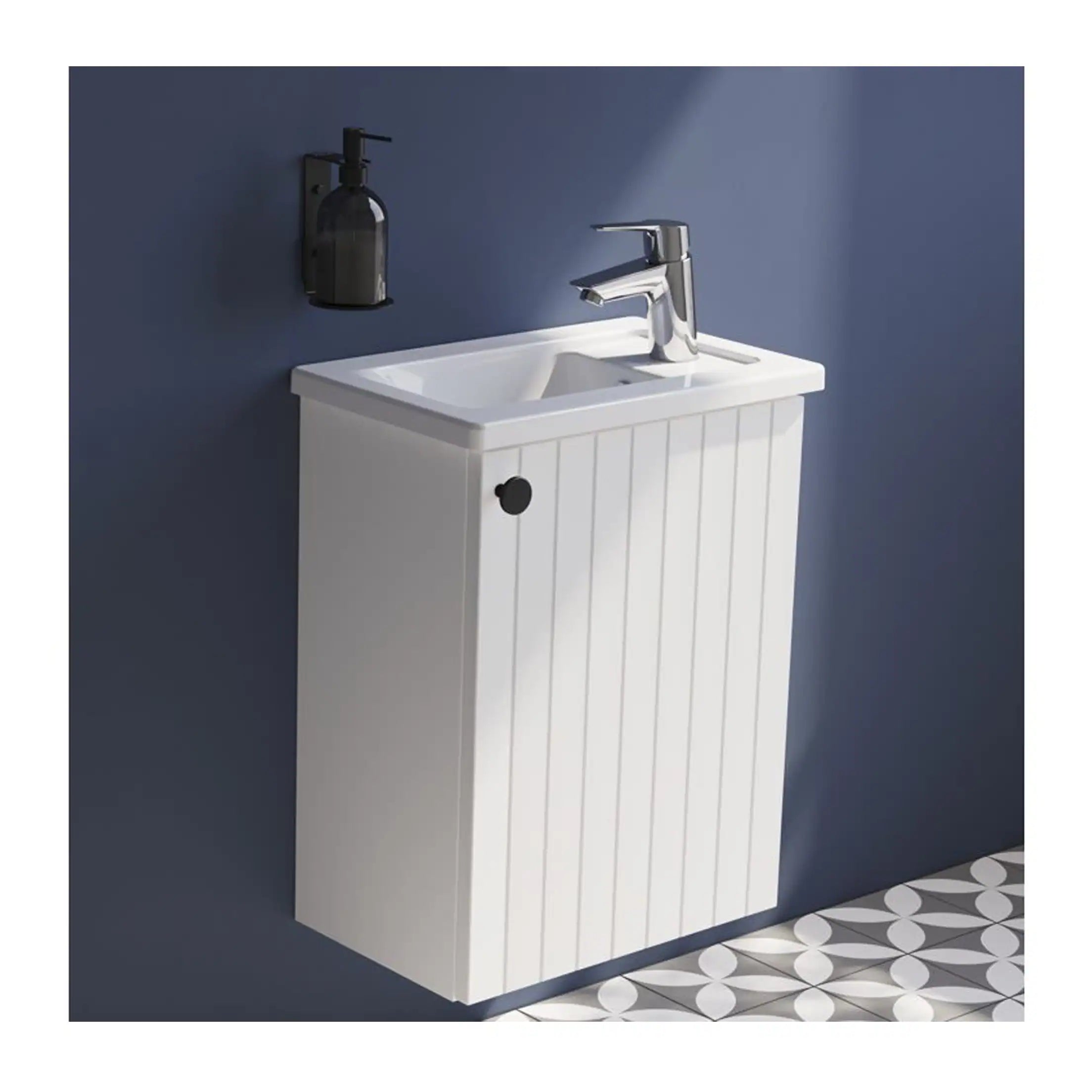 White bathroom vanity with integrated sink and modern chrome tap, set against a navy blue wall with a black soap dispenser. Perfect for compact bathroom storage and contemporary decor.