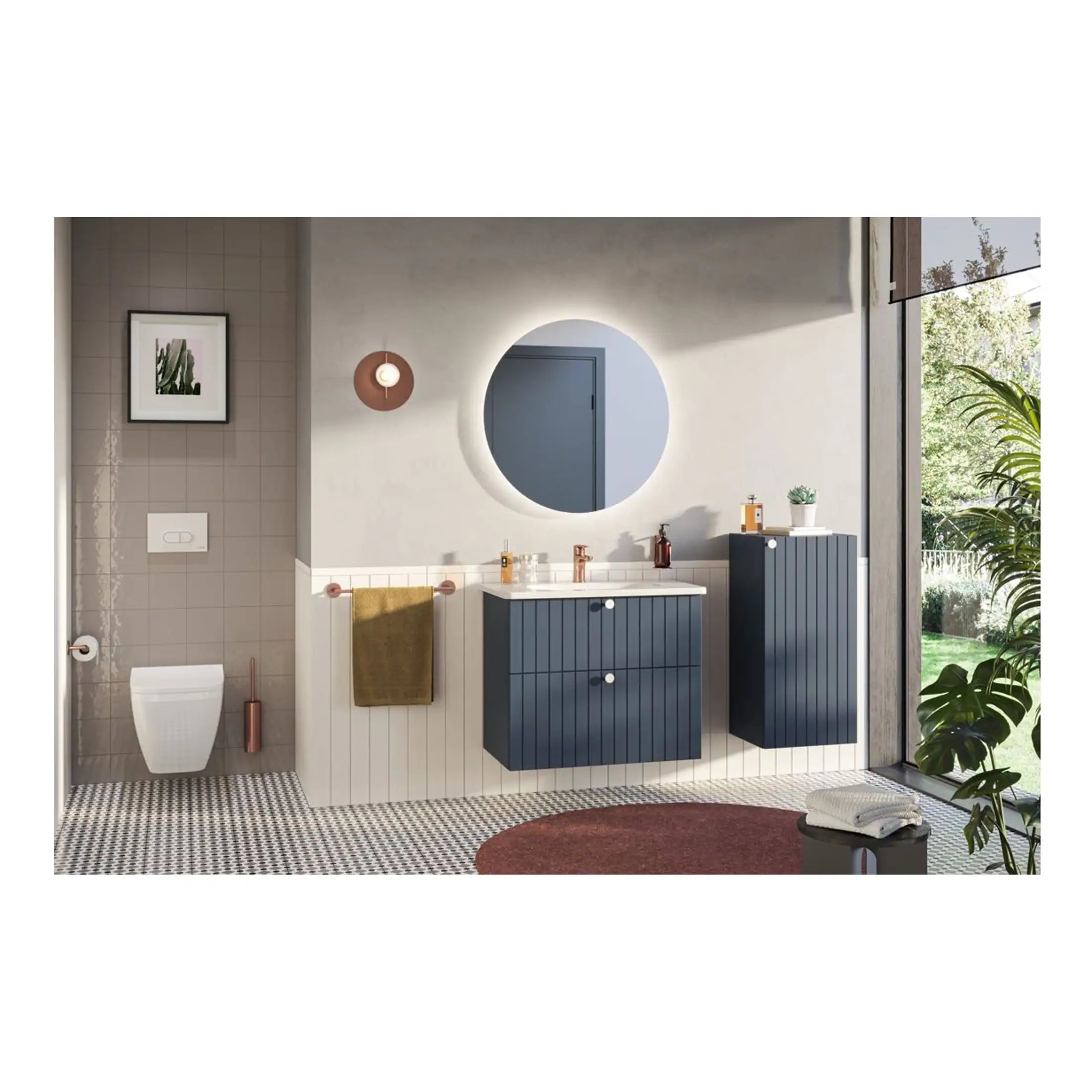 Contemporary bathroom with blue cabinetry, modern round mirror with lighting, wall-mounted toilet, and decorative elements including a potted plant and patterned floor tiles, creating a stylish and functional space.