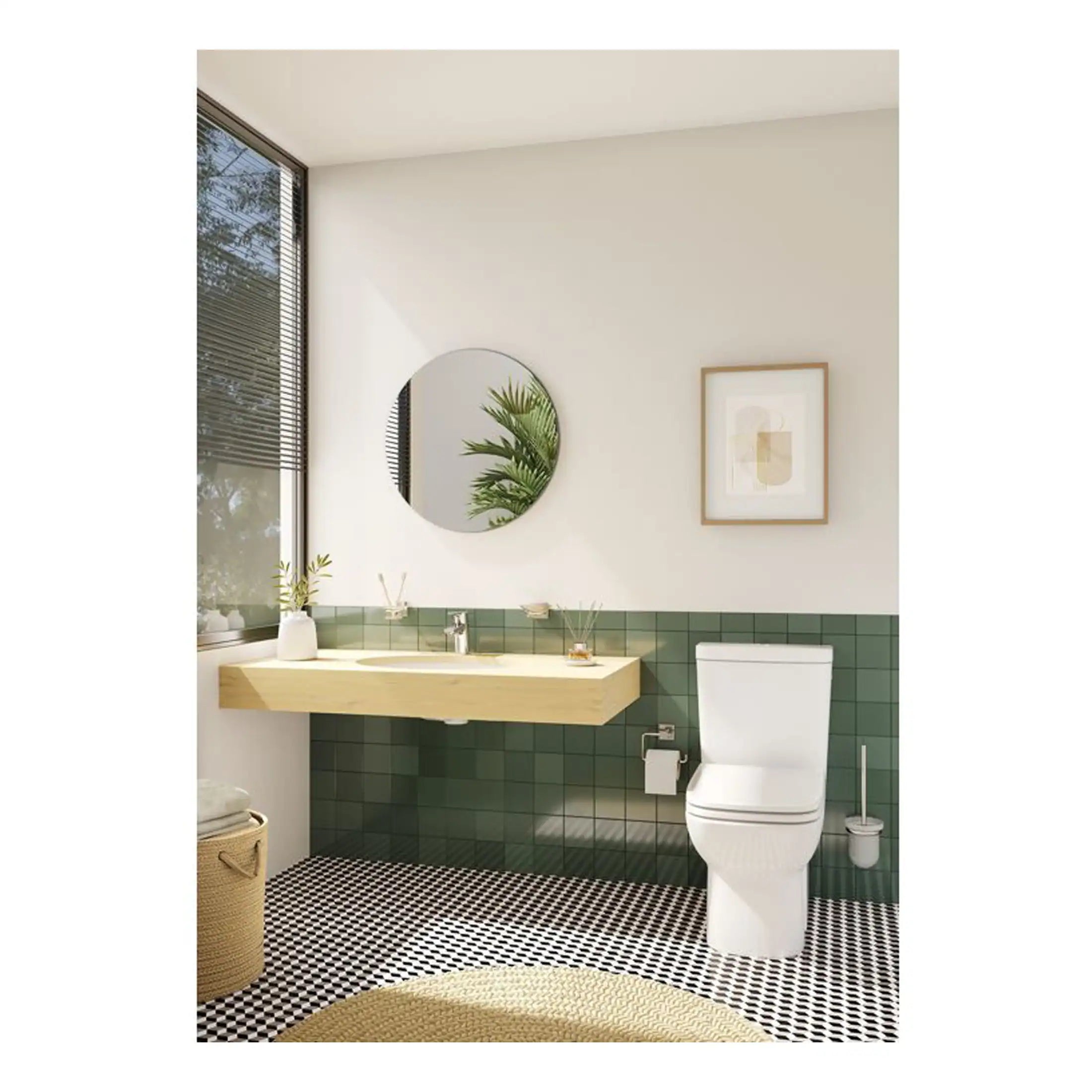 Modern bathroom with green tiled wall, wooden vanity, round mirror, and white toilet, featuring minimalist decor and natural light for a stylish, functional space.