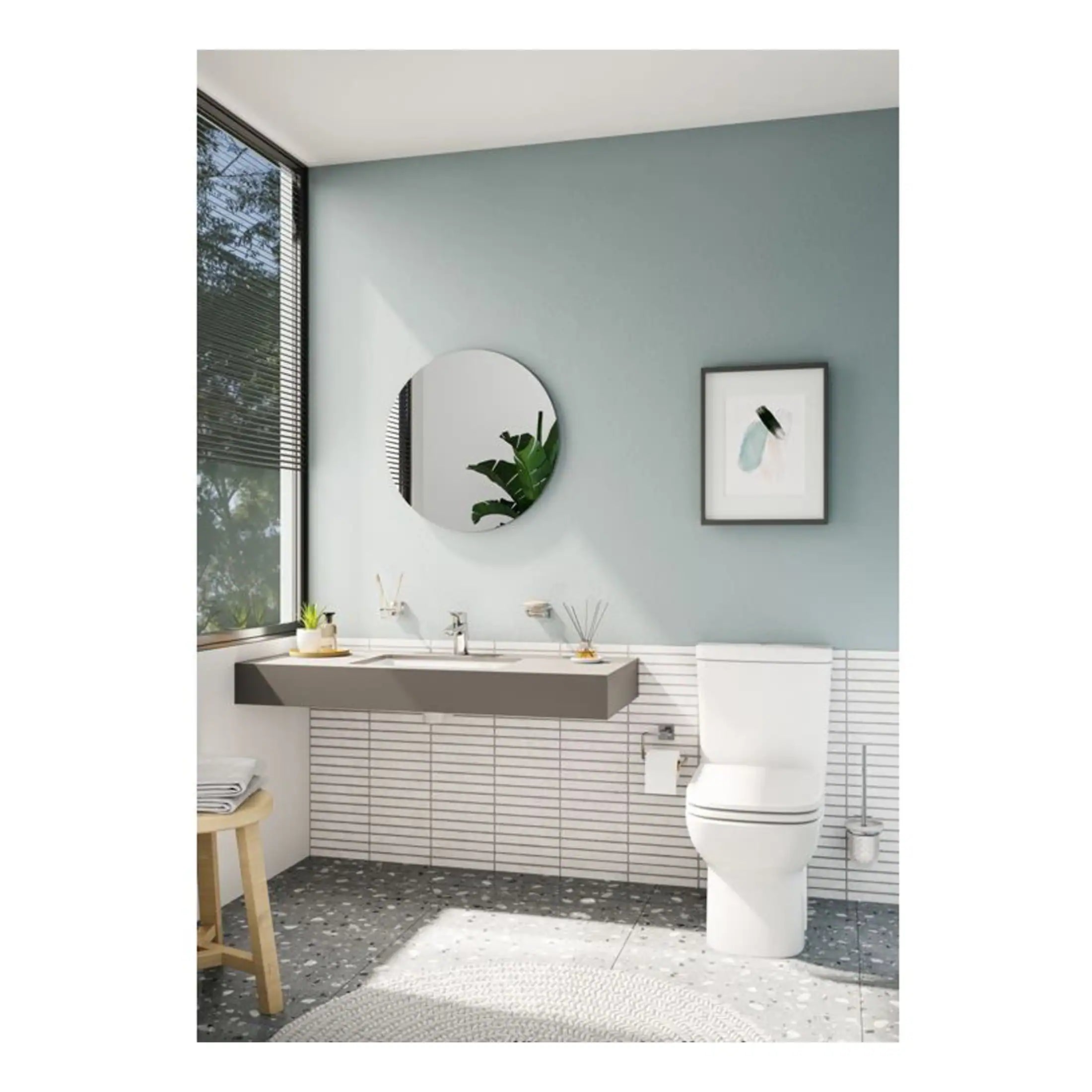 Modern minimalist bathroom featuring a sleek white toilet, wall-mounted sink, round mirror, and stylish decor, set against a light blue wall with large windows for natural light.