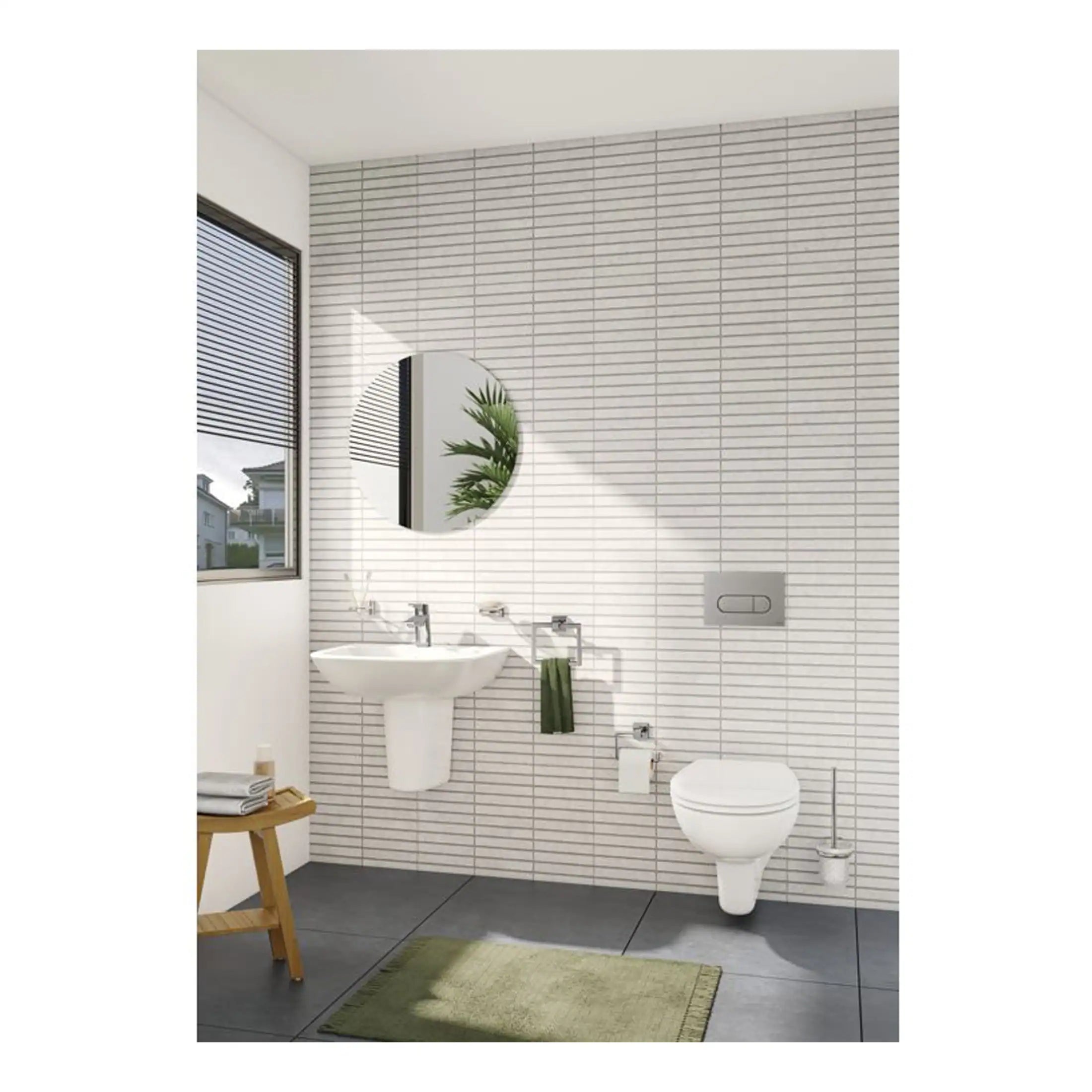 Modern white bathroom with wall-mounted toilet, sink, round mirror, and natural light, showcasing contemporary bathroom fixtures and clean design.