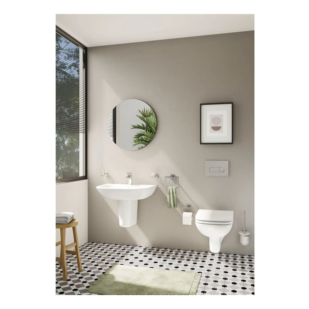 Sleek modern bathroom with wall-mounted toilet and pedestal sink, minimalist decor, large window, stylish framed art, round mirror, black and white patterned floor, light neutral tones, and contemporary plumbing fixtures.