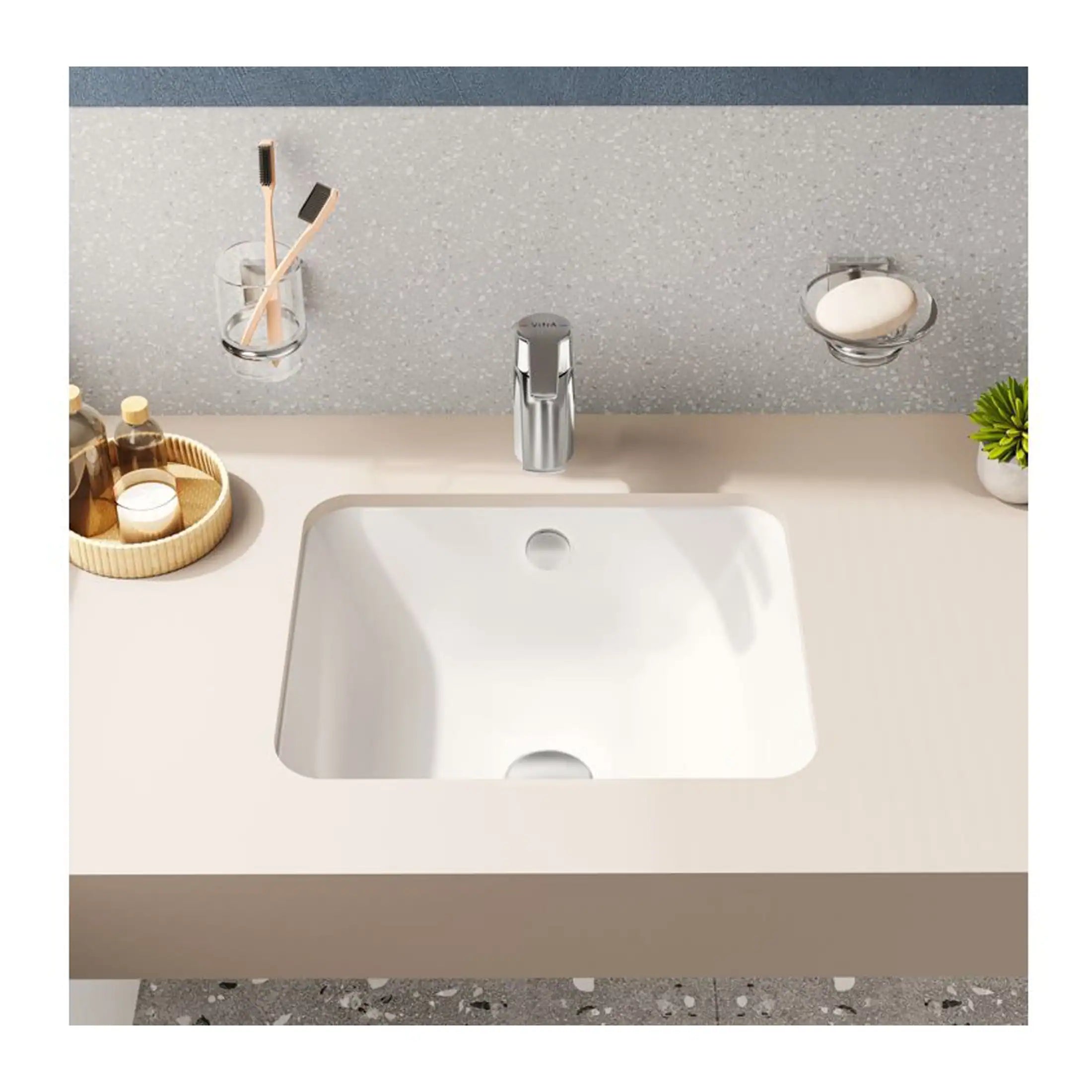 Sleek white bathroom sink with modern chrome tap, set against a textured grey backsplash with minimalistic accessories. Perfect for contemporary bathroom design and plumbing solutions.