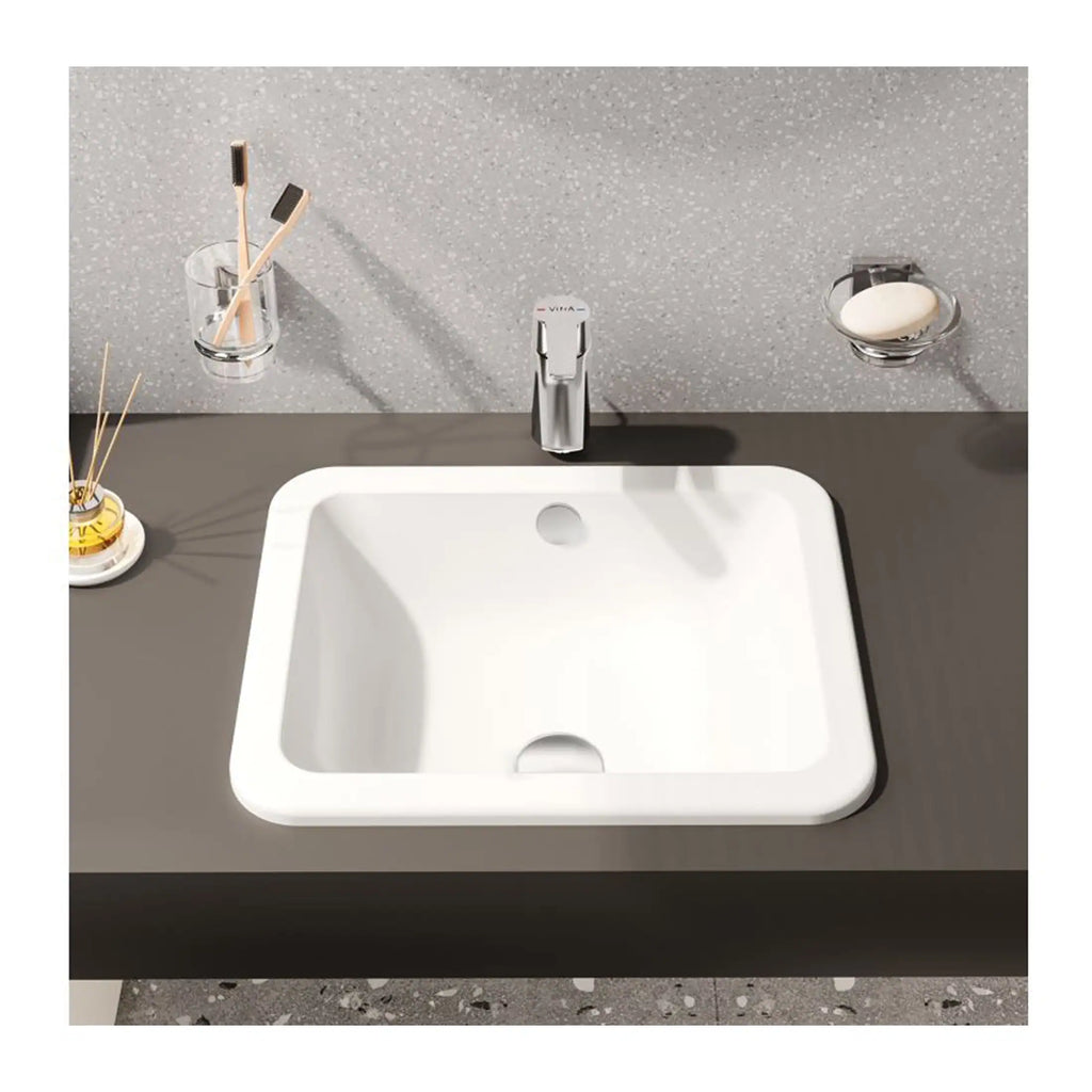 Sleek modern bathroom sink with minimalist design, featuring a chrome tap and accessories, perfect for contemporary bathroom decor.