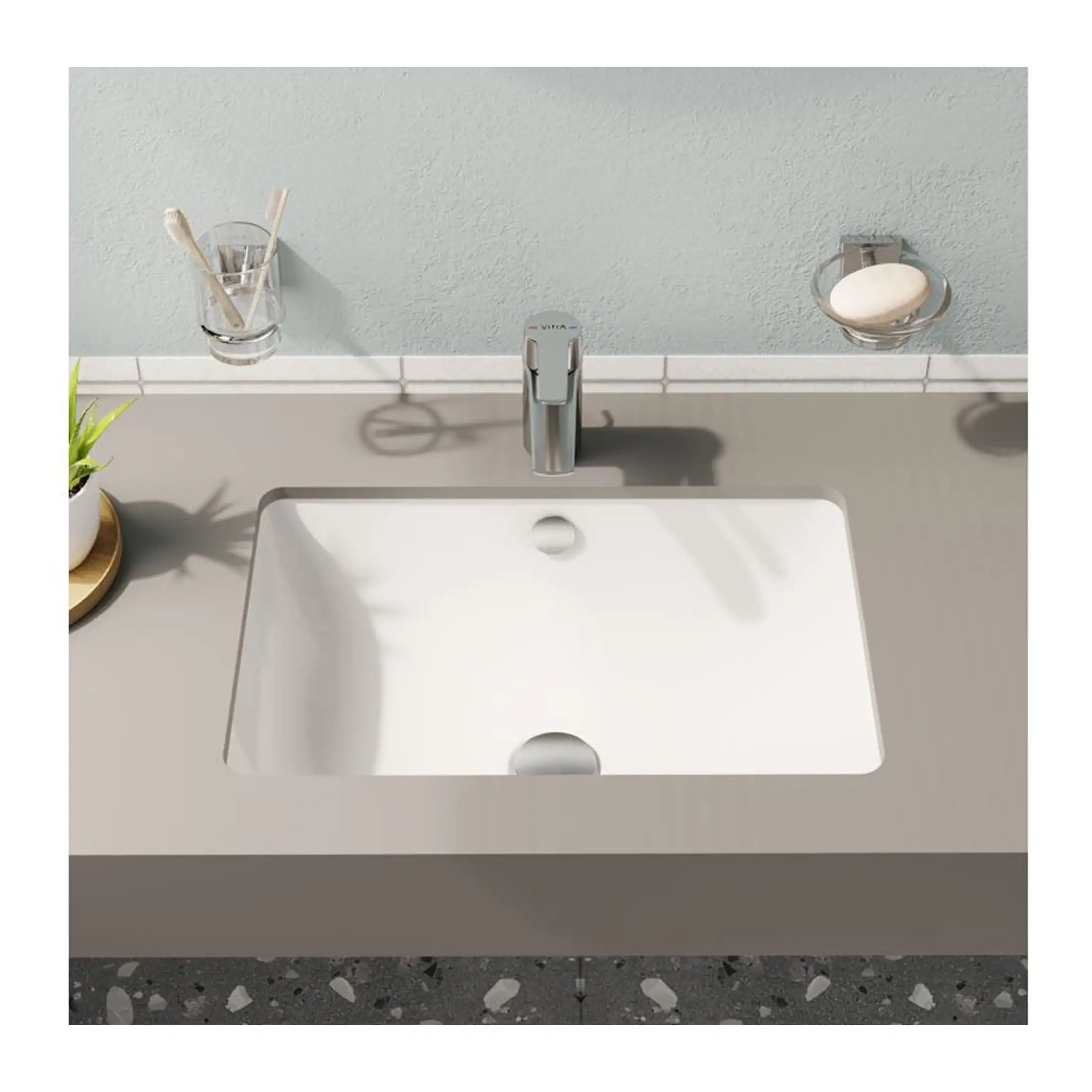 Sleek white bathroom sink with modern chrome tap, mounted on a beige vanity unit, featuring bathroom accessories and a neutral wall background, ideal for contemporary bathroom design.