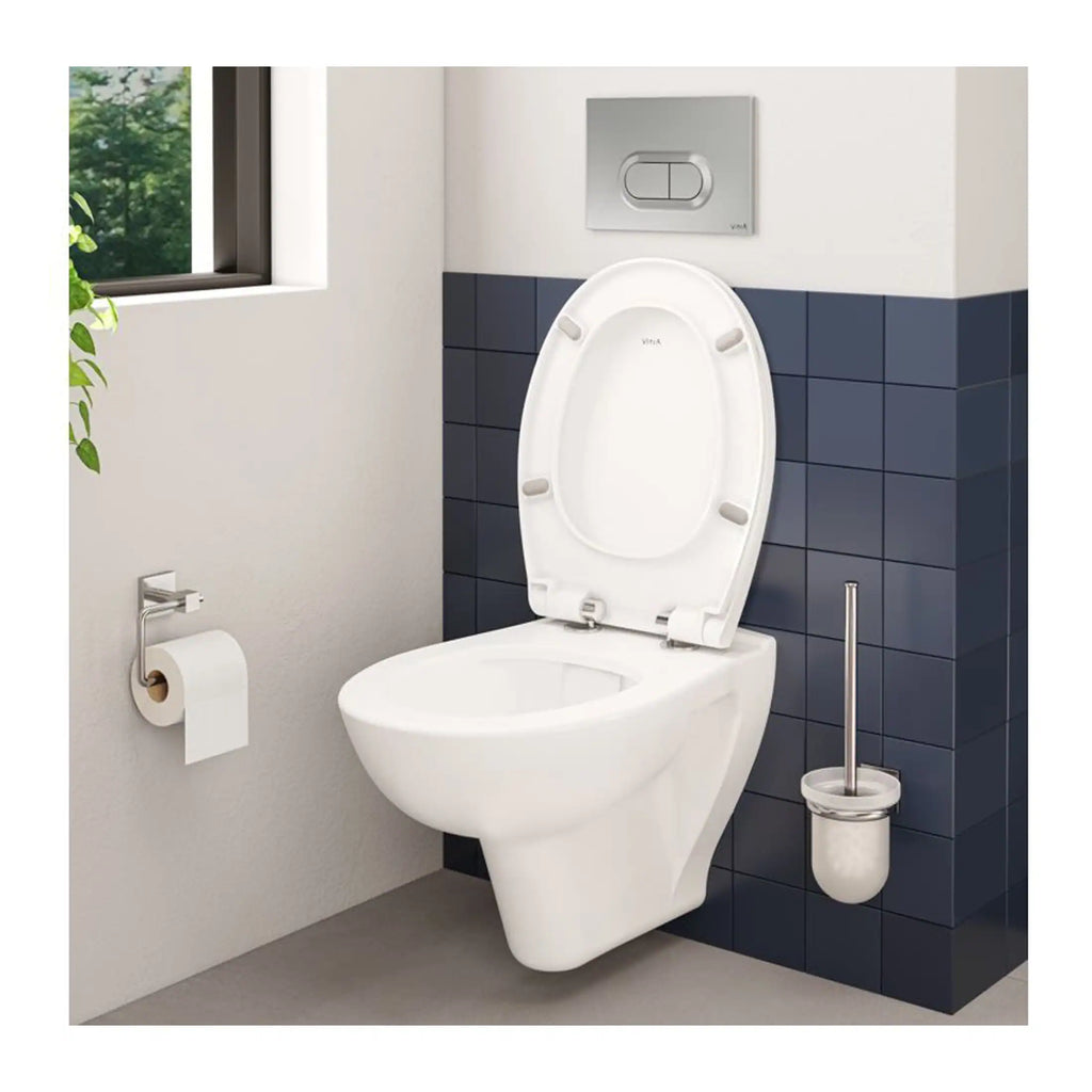 Contemporary white toilet with dual flush system, toilet brush, and toilet paper holder in modern bathroom with navy tiled accent wall and natural light from nearby window.