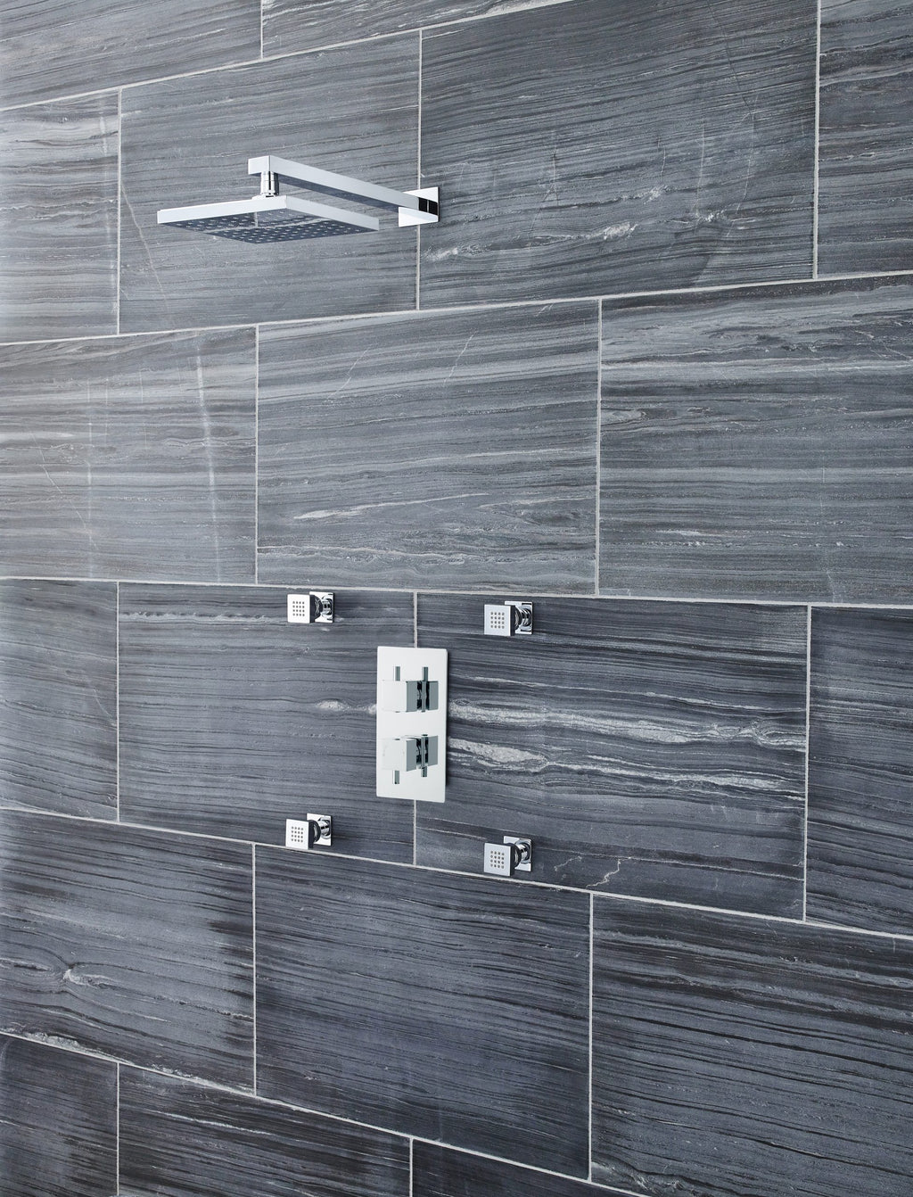Modern grey tiled shower wall with a sleek rainfall showerhead and contemporary mixer controls, ideal for luxury bathroom renovations and stylish wet room designs.