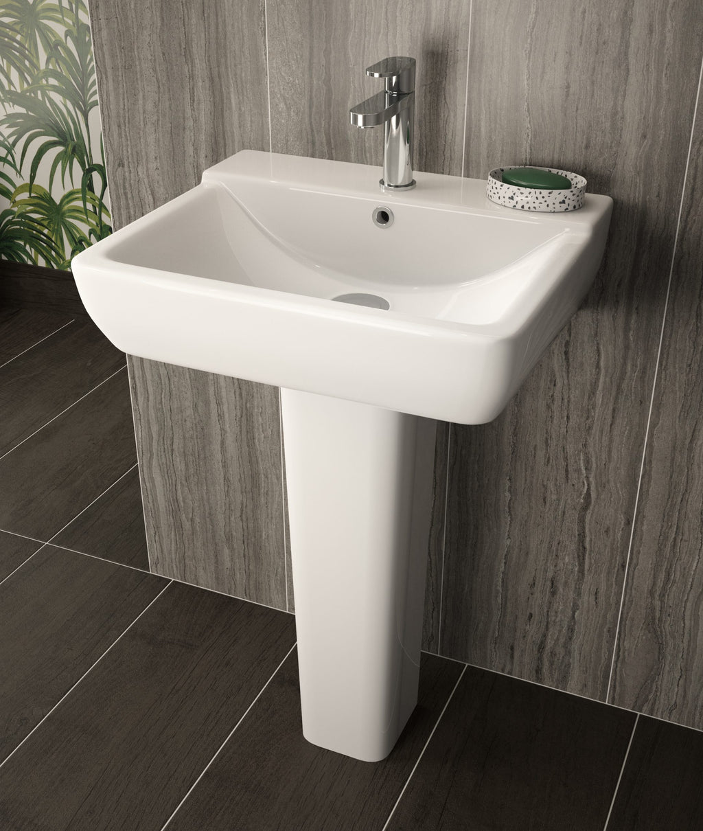 Contemporary white ceramic pedestal sink with chrome tap in modern bathroom setting, perfect for stylish and functional bathroom design, featuring neutral wall tiles and dark floor tiles.