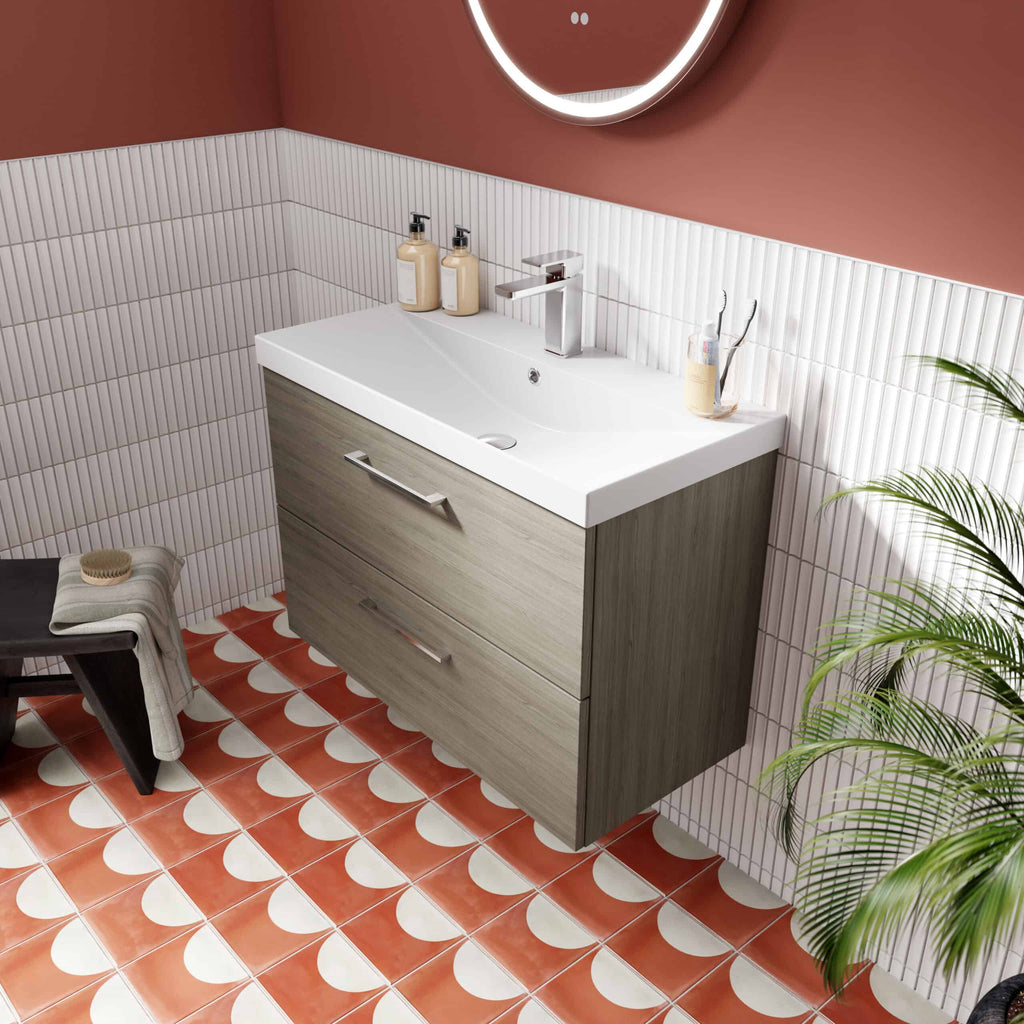 Modern bathroom vanity with wooden drawers, white ceramic sink, chrome faucet, and bathroom essentials on a stylish coral and white tiled floor with wall-mounted mirror.