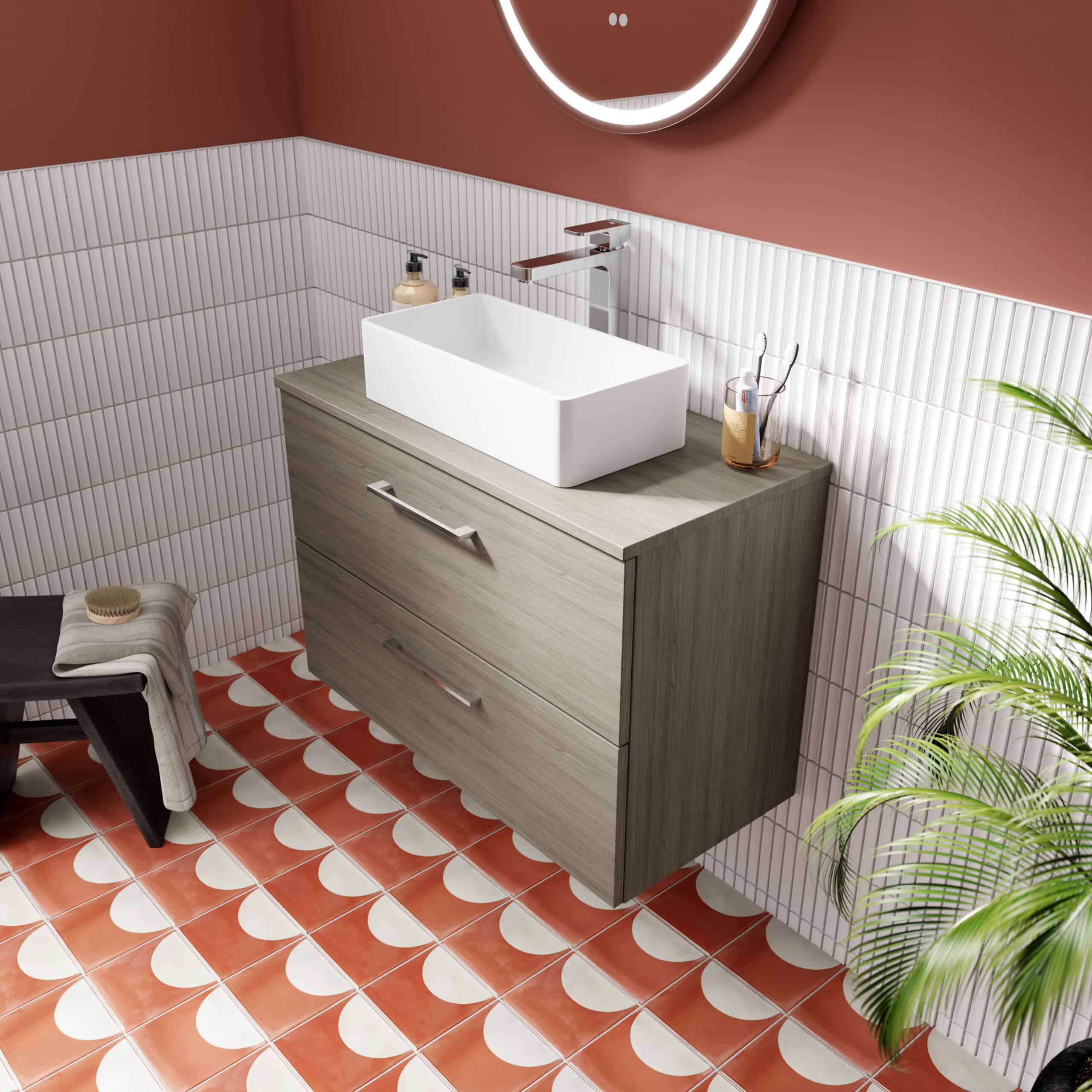 Modern bathroom vanity with vessel sink, wooden cabinet with drawers, pink and white tiled walls, terracotta patterned floor, and interior decor for stylish bathroom design.
