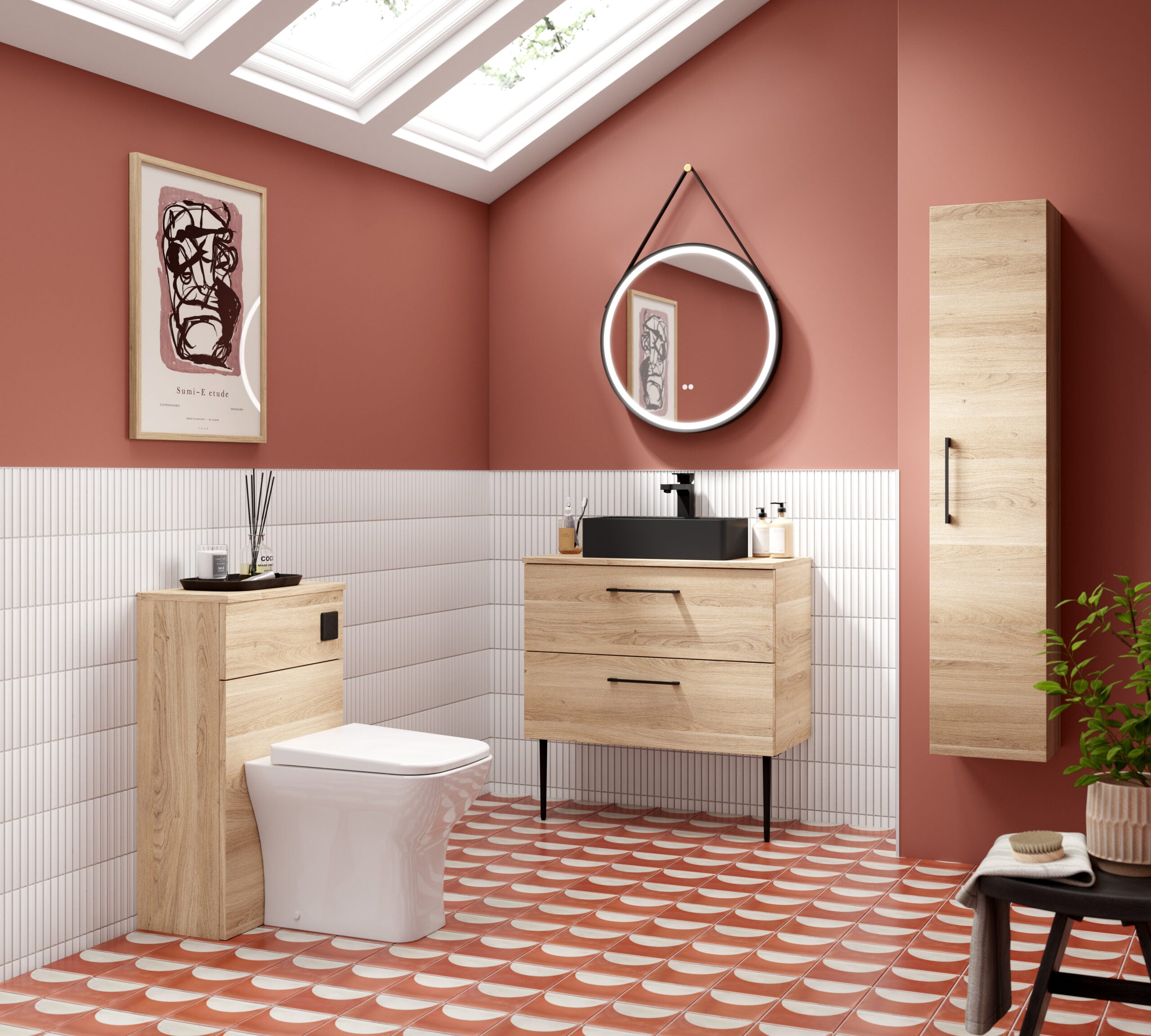 Modern bathroom with wooden vanity and storage, black basin sink, circular illuminated mirror, white tiling, terracotta floor tiles, and pink wall accents for stylish and functional bathroom design.