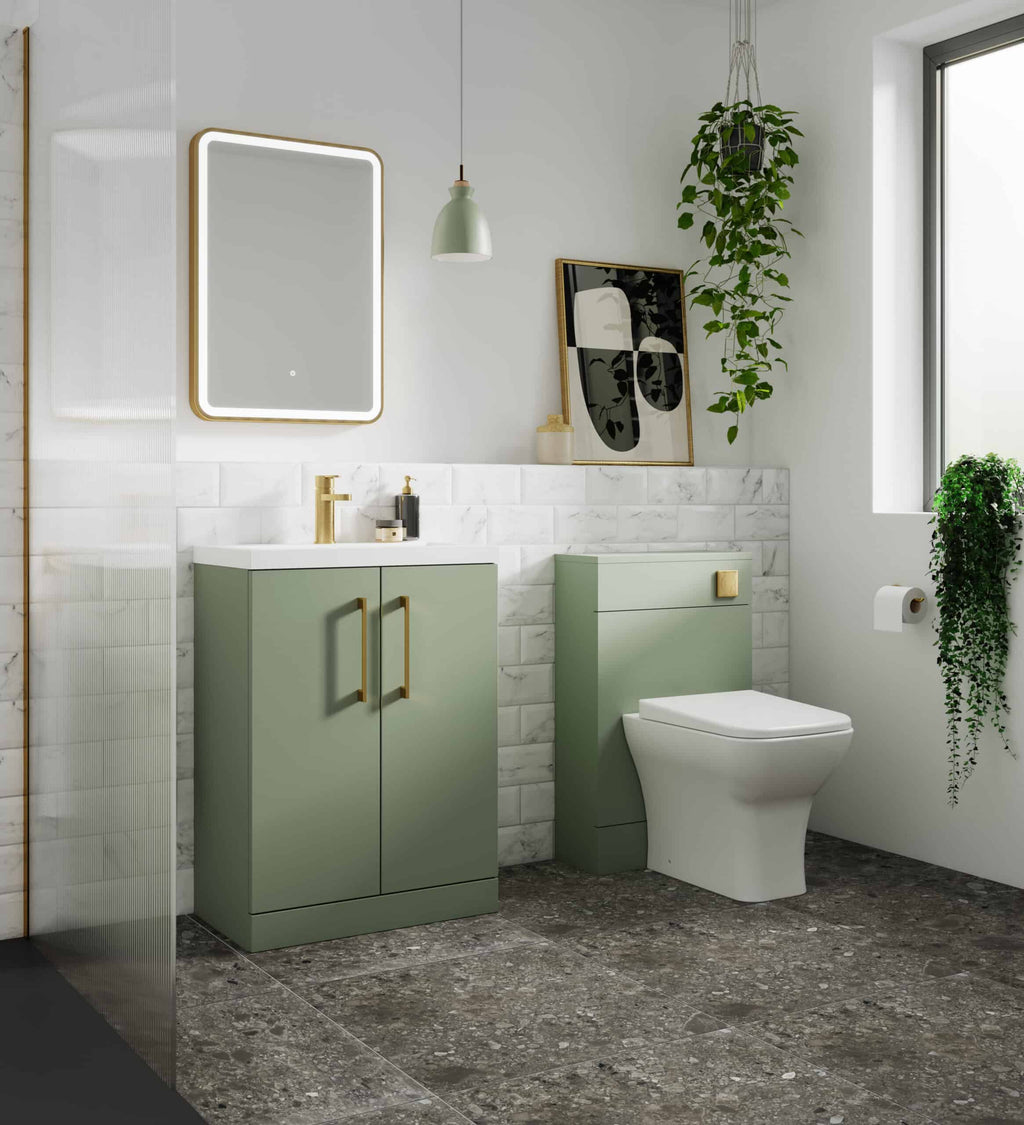 Luxurious green bathroom vanity with gold handles and a modern toilet in a stylish, bright bathroom with marble tiles, hanging plants, and contemporary decor.