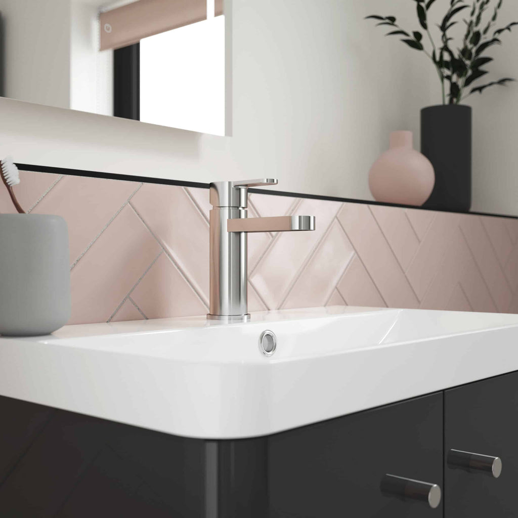 Sleek modern bathroom sink with chrome tap, pink tiling, and decorative vases for contemporary bathroom design. Perfect for stylish, functional bathroom spaces.