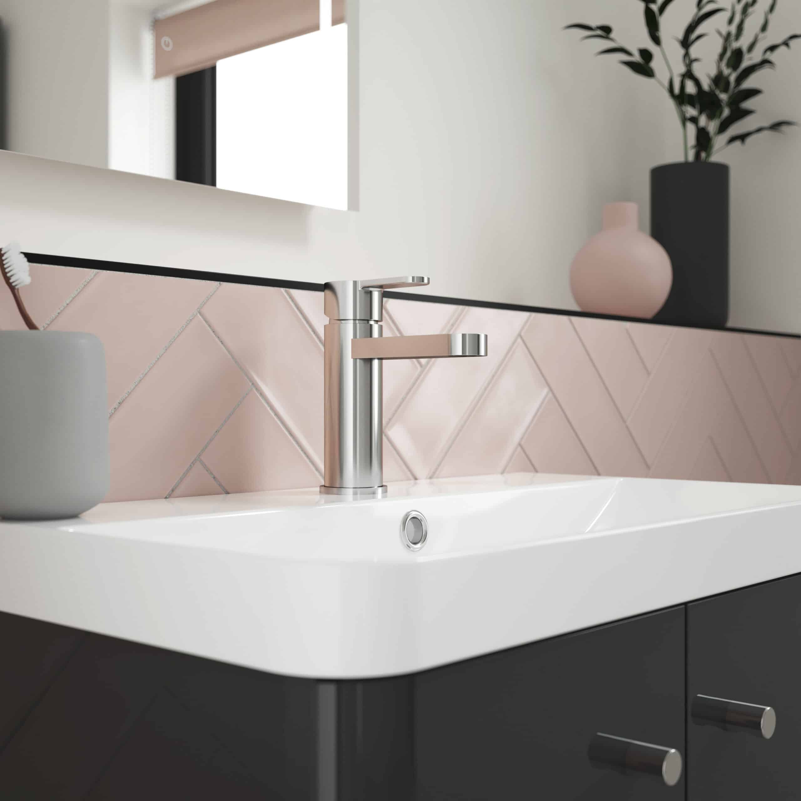 Sleek modern bathroom sink with chrome tap, pink tiling, and decorative vases for contemporary bathroom design. Perfect for stylish, functional bathroom spaces.