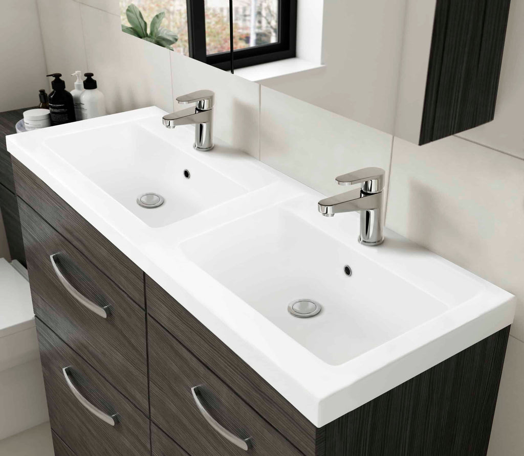 Double ceramic bathroom sink with modern chrome mixers on a dark wood vanity unit. Ideal for contemporary bathrooms, featuring a minimalist design with ample storage and sleek fixtures.