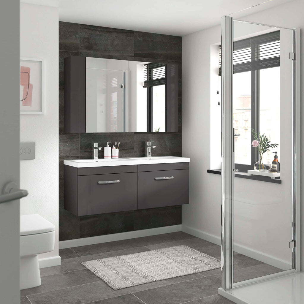 Contemporary double vanity bathroom with dark grey cabinetry, large mirror, and natural light from a window, showcasing modern bathroom design and storage solutions.