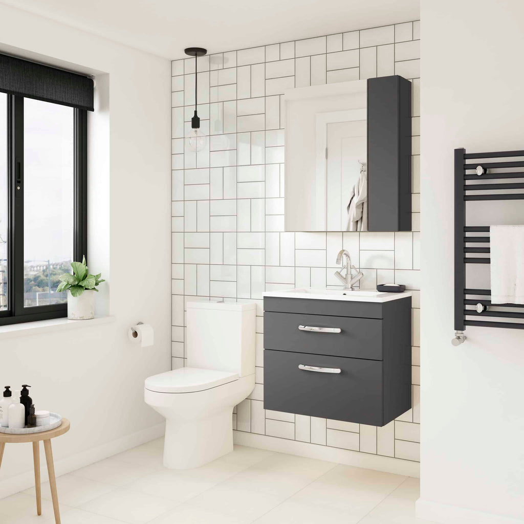 Modern minimalist bathroom with sleek black vanity, wall-mounted mirror, and towel warmer, featuring clean white tiles and ample natural light for a stylish bathroom renovation.