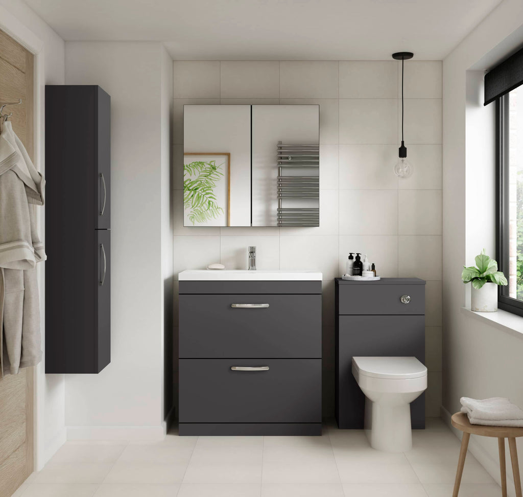 Sleek modern grey bathroom vanity and storage cabinets with white tile walls and contemporary fixtures, including a mirror and wall-mounted radiator, in a bright natural light bathroom setting.
