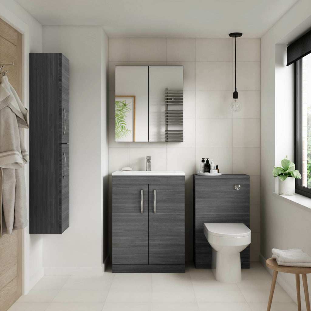 Modern grey bathroom vanity with white sink and wall-mounted mirror, adjacent to a toilet and black towel radiator in a contemporary bathroom with natural light from a large window.