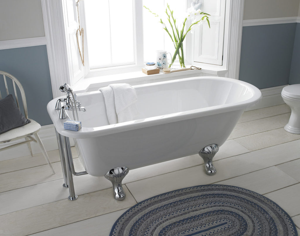 Elegant freestanding white clawfoot bathtub in a classic bathroom, featuring vintage-style chrome fixtures and a peaceful, light-filled setting with decorative elements and botanical accents.