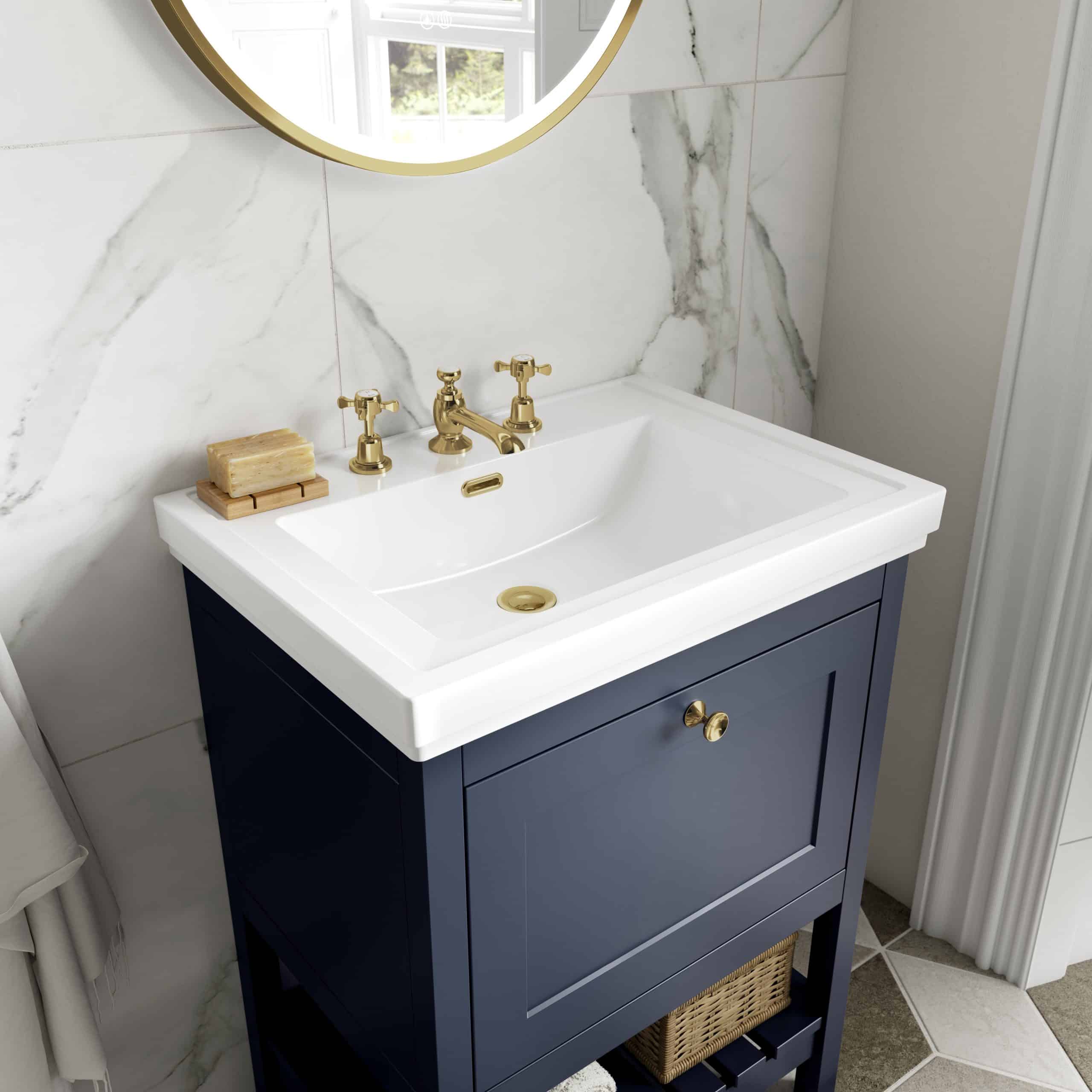 Classic bathroom vanity with navy blue cabinet and white ceramic sink, featuring gold fixtures and a marble backsplash for luxurious bathroom design.