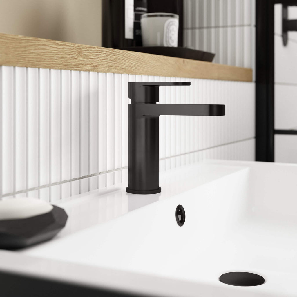 Brushed black bathroom faucet mounted on a modern white sink in a contemporary bathroom setting.