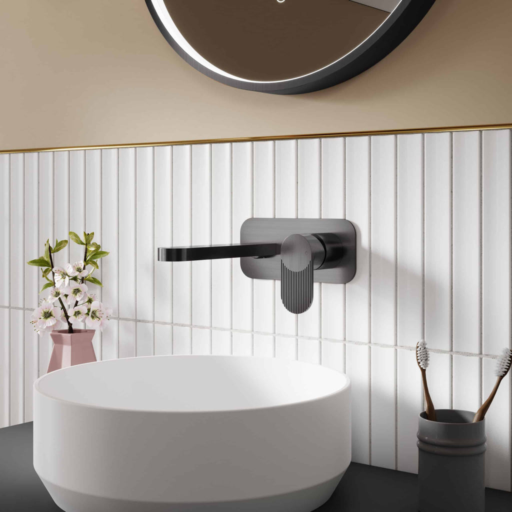 Sleek black matte bathroom sink faucet with modern handle, set against white tiled wall, complemented by a round mirror, pink flower vase, and toothbrush holder for stylish bathroom decor.