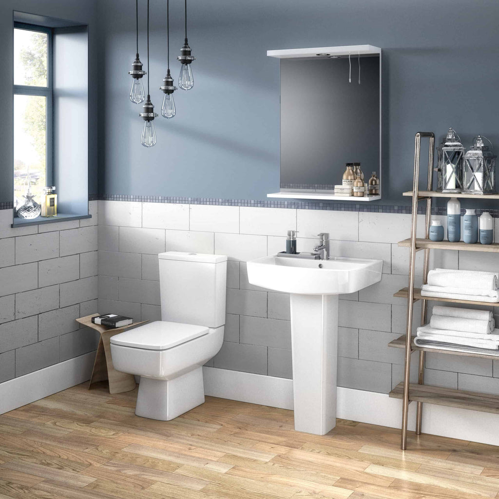 Modern bathroom with white toilet and sink, wooden shelving, decorative lanterns, and soft blue walls in a contemporary design.