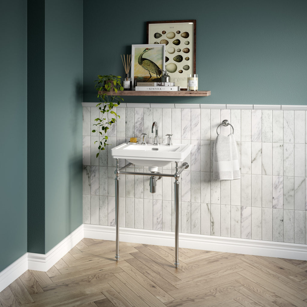Elegant vintage bathroom sink with chrome legs and a white ceramic basin, set against a stylish tiled wall and teal painted wall, perfect for classic bathroom decor.