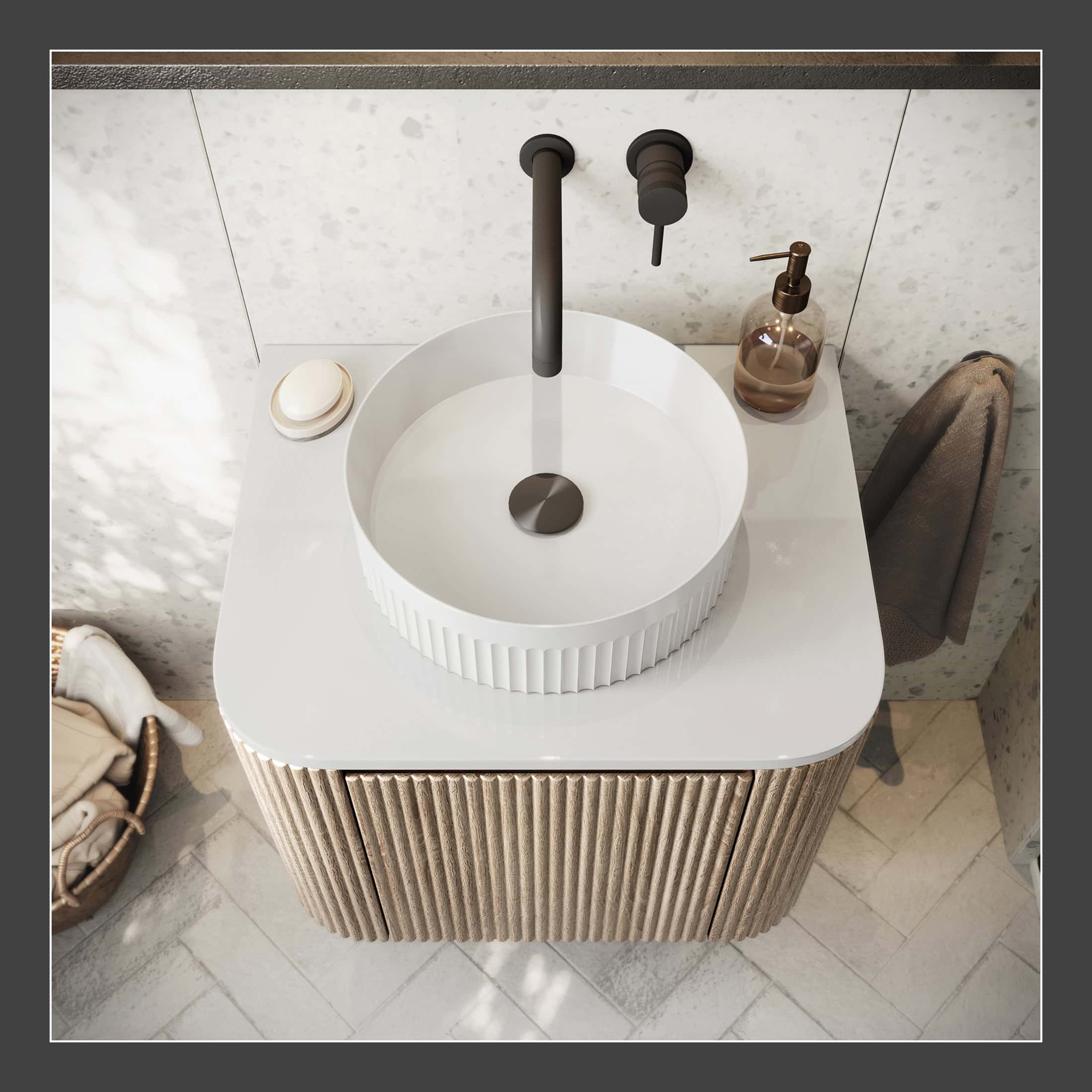 Modern round bathroom sink with black matte tap on a white countertop, featuring a textured beige cabinet base, soap dispenser, and towel, ideal for contemporary bathroom design.