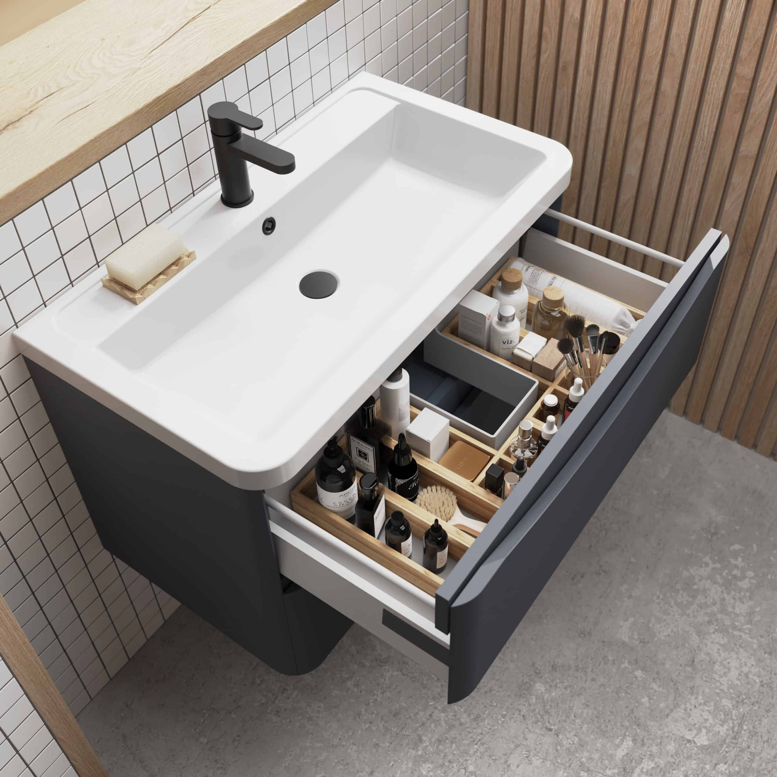 Organised bathroom vanity with open drawer containing skincare, toiletries, and makeup products, featuring a modern white sink and black faucet, perfect for stylish bathroom storage solutions.