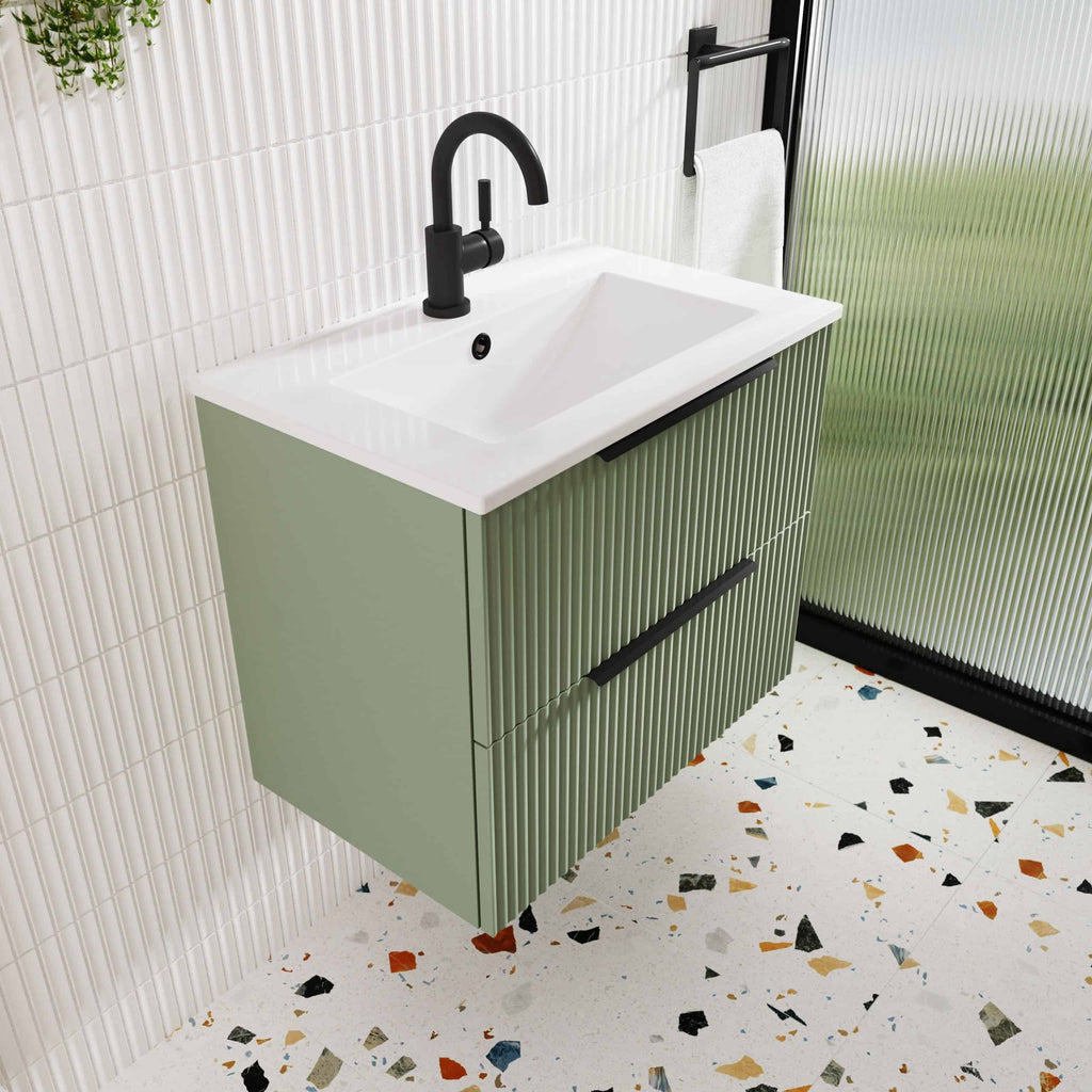 Modern bathroom vanity with green ribbed cabinet, white ceramic sink, and black matte faucet in a contemporary bathroom setting.