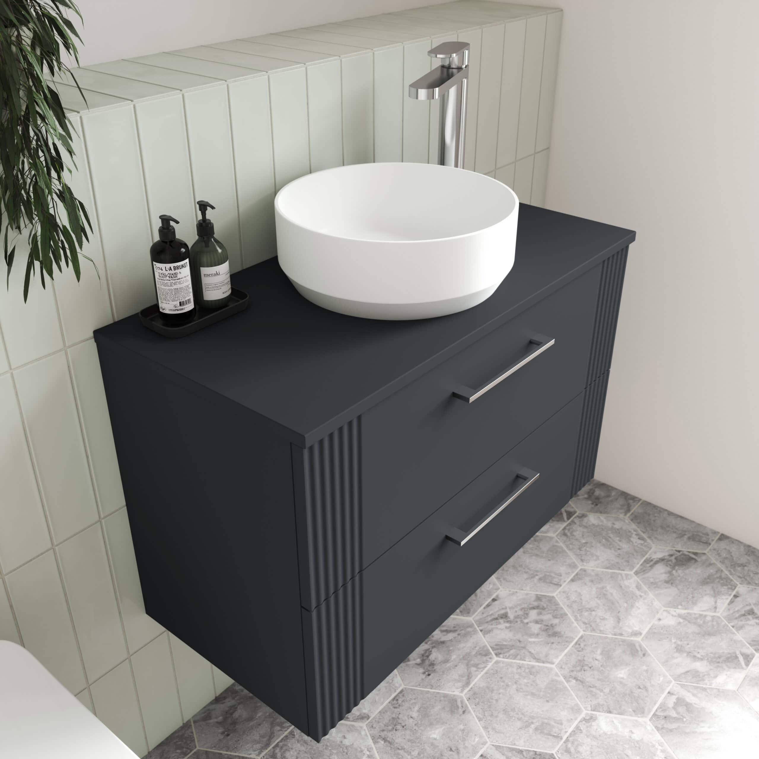 Deep grey bathroom vanity with a modern round white vessel sink and chrome tap, customised with black soap dispensers, ideal for contemporary bathroom decor.
