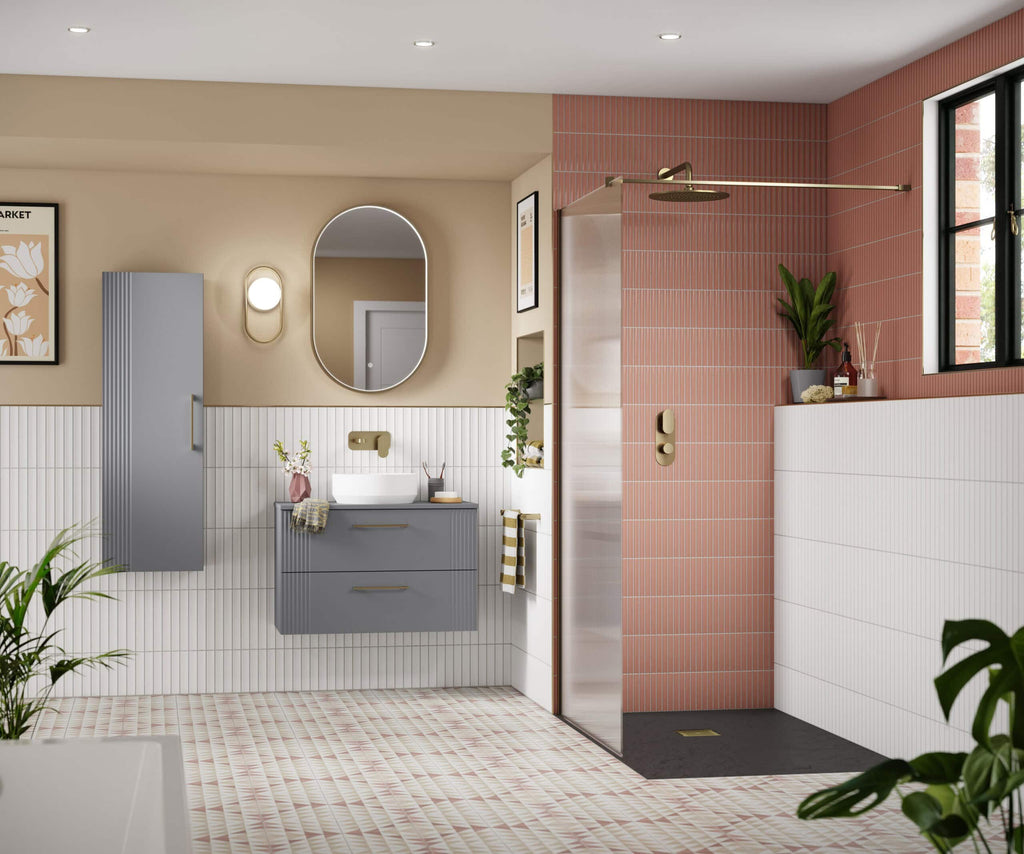 Modern bathroom with a stylish grey vanity, oval mirror, and a walk-in shower featuring pink tiles and black flooring, accented with green plants and contemporary fixtures.