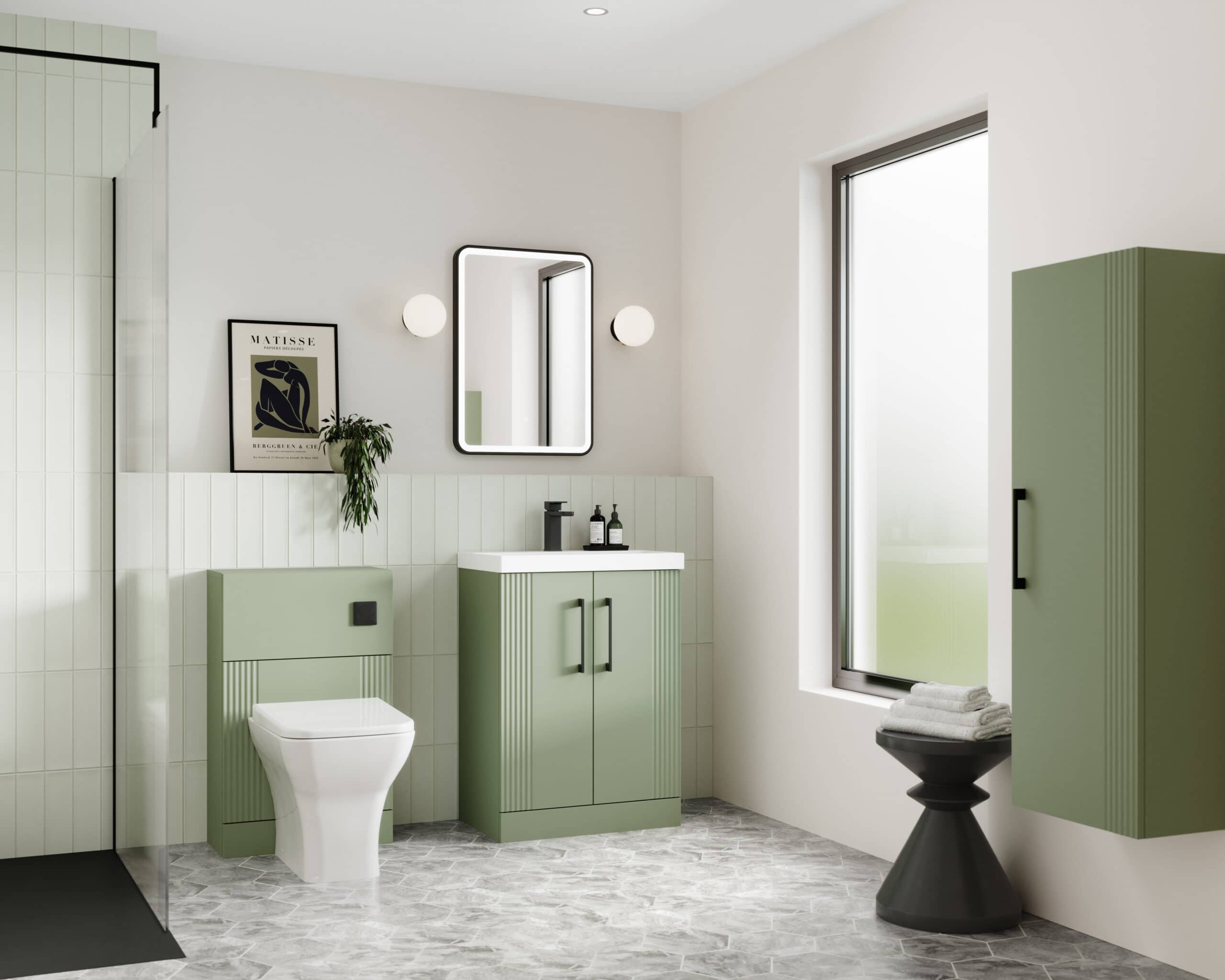 Modern green bathroom vanity cabinet with matching storage, wall-mounted mirror, and fixtures in a bright, minimalist bathroom with natural light.
