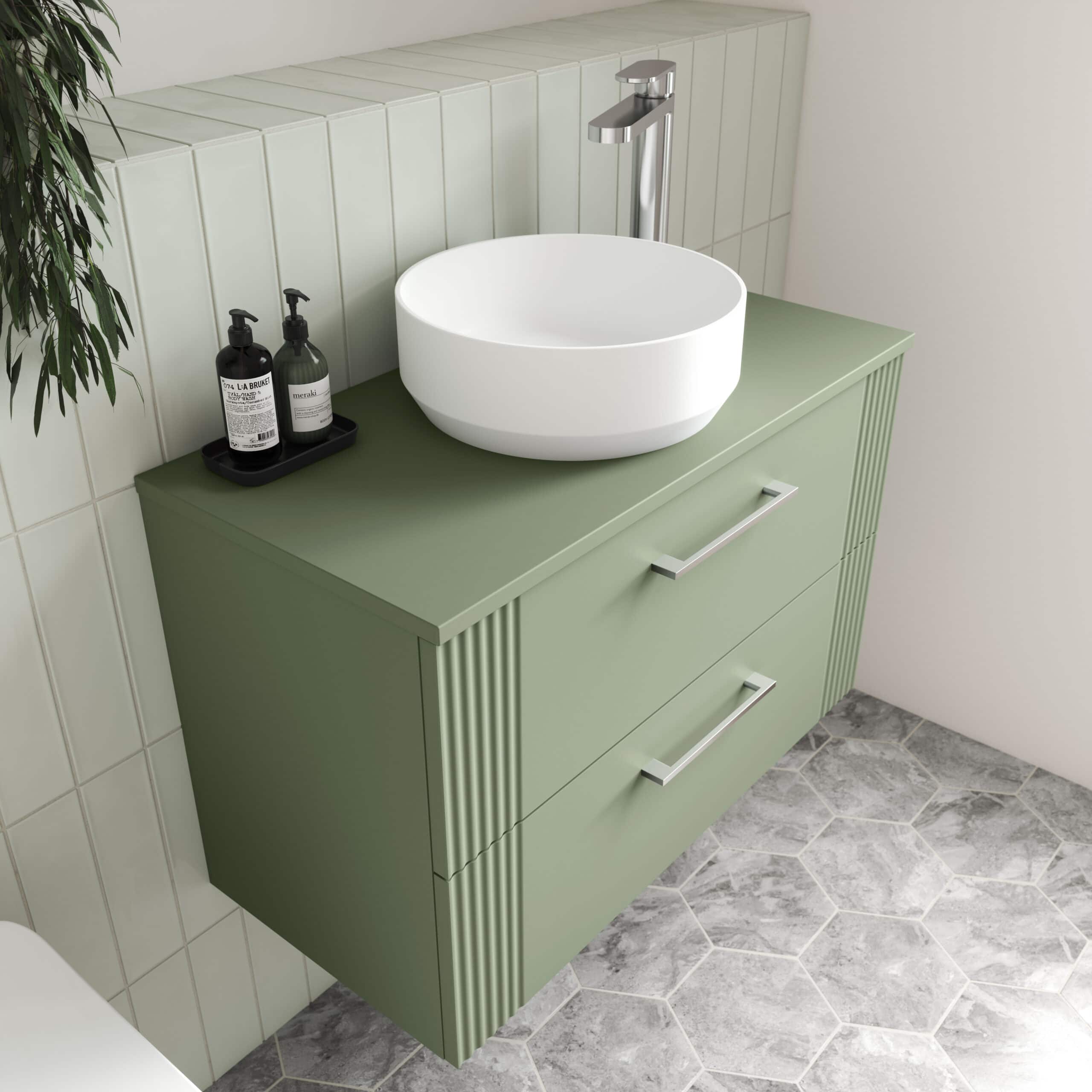 Sleek green bathroom vanity with integrated drawers, modern white round vessel sink, and contemporary chrome tap featuring storage bottles, ideal for stylish bathroom upgrades.