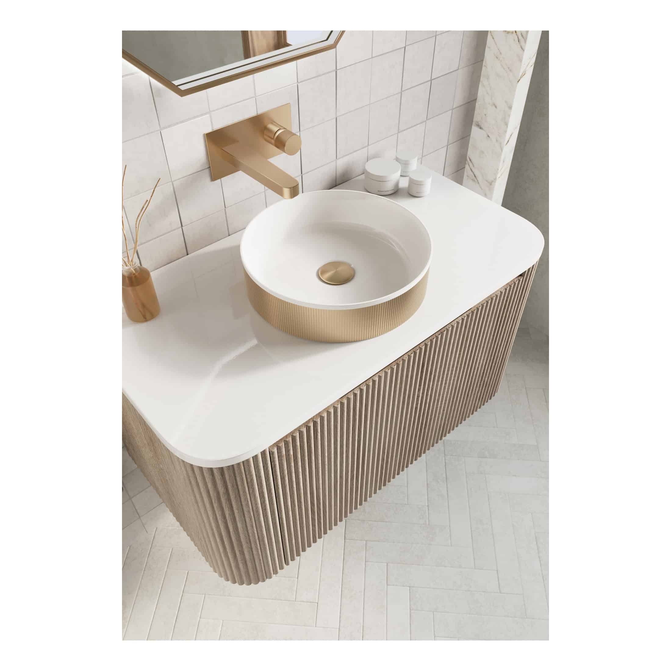 Sleek modern bathroom vanity with a round white vessel sink featuring a gold base, wall-mounted gold faucet, and minimalist decor, showcasing luxury bathroom design.