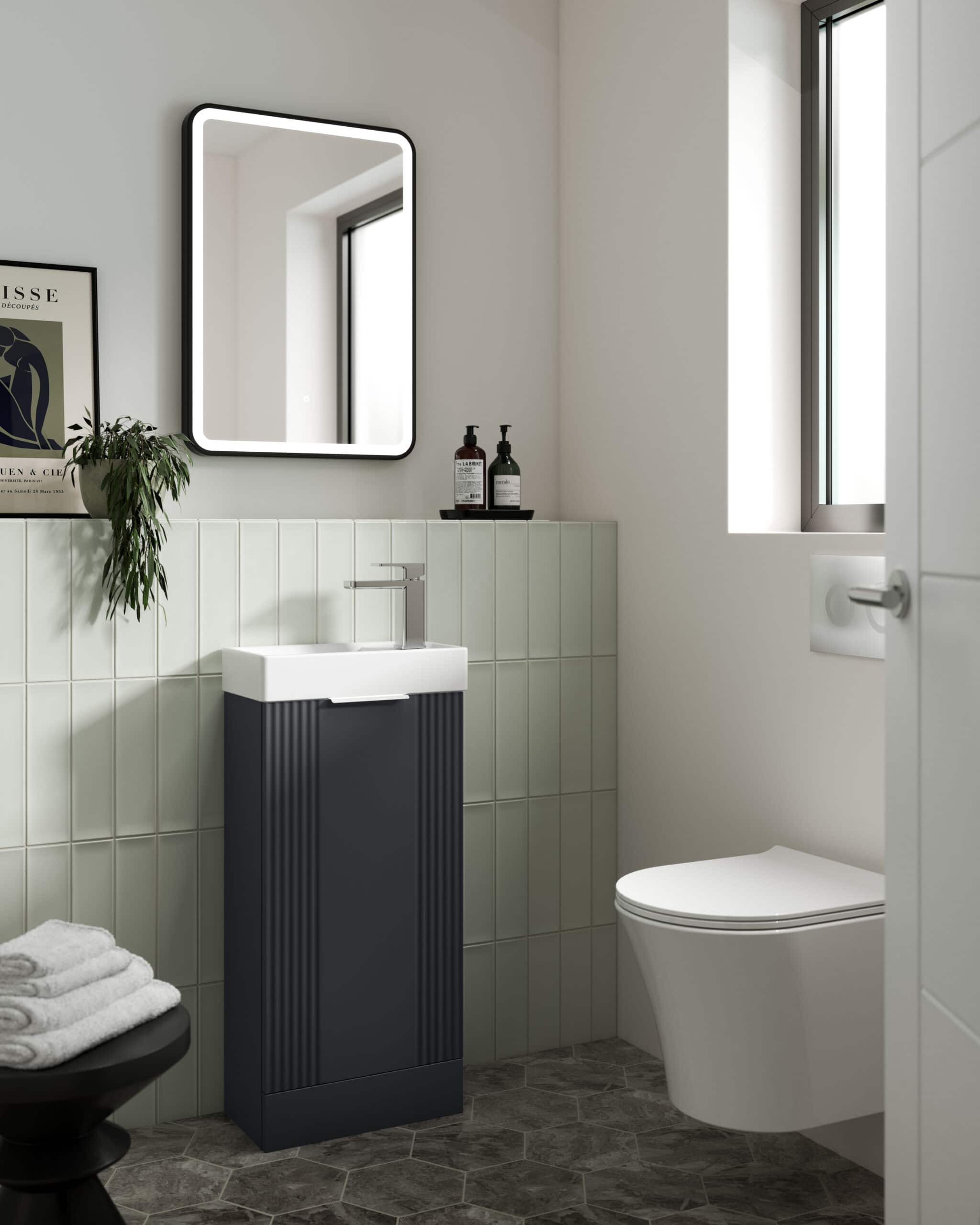 Sleek modern bathroom featuring a stylish black and white freestanding sink, illuminated mirror, and contemporary toilet, all styled with minimalist decor. Perfect for modern bathroom design.