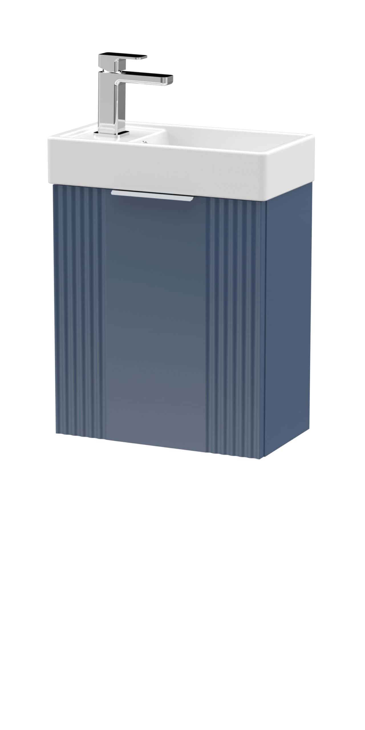 Chrome bathroom vanity unit with white ceramic sink and modern chrome tap. Stylish blue cabinet with vertical grooves, ideal for contemporary bathroom storage. Perfect for compact spaces.